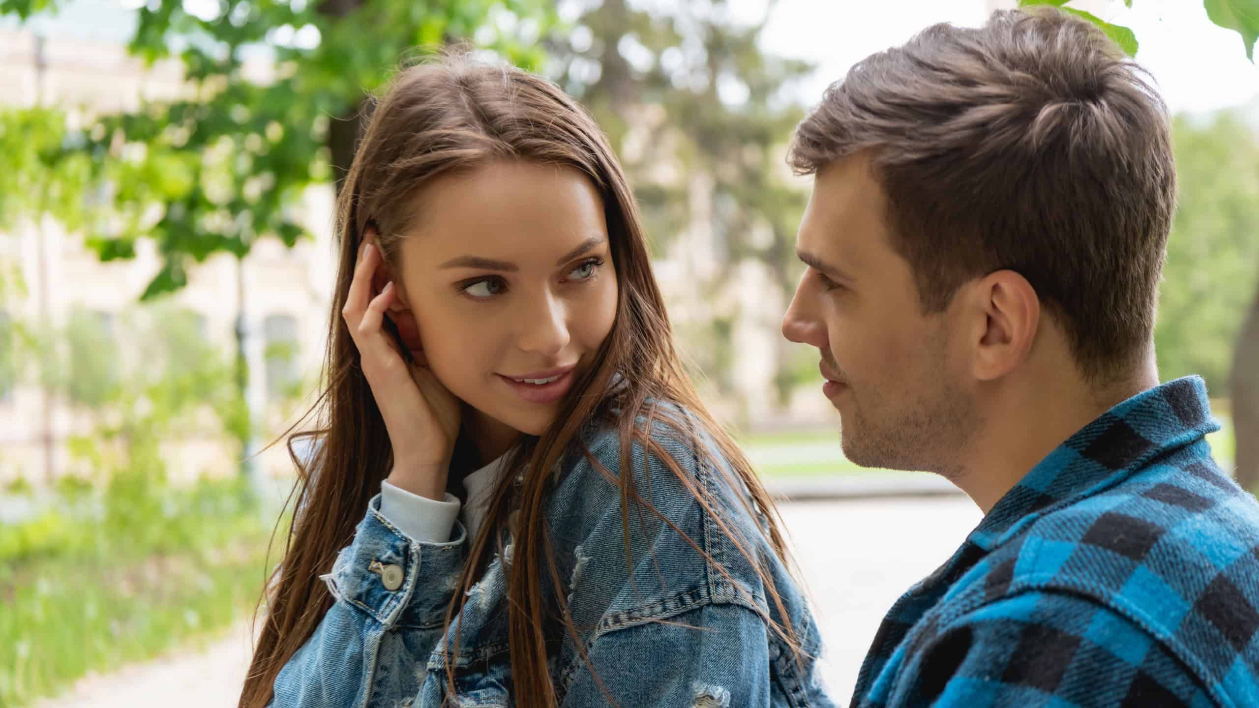 Pretty girl touching hair while flirting with boyfriend