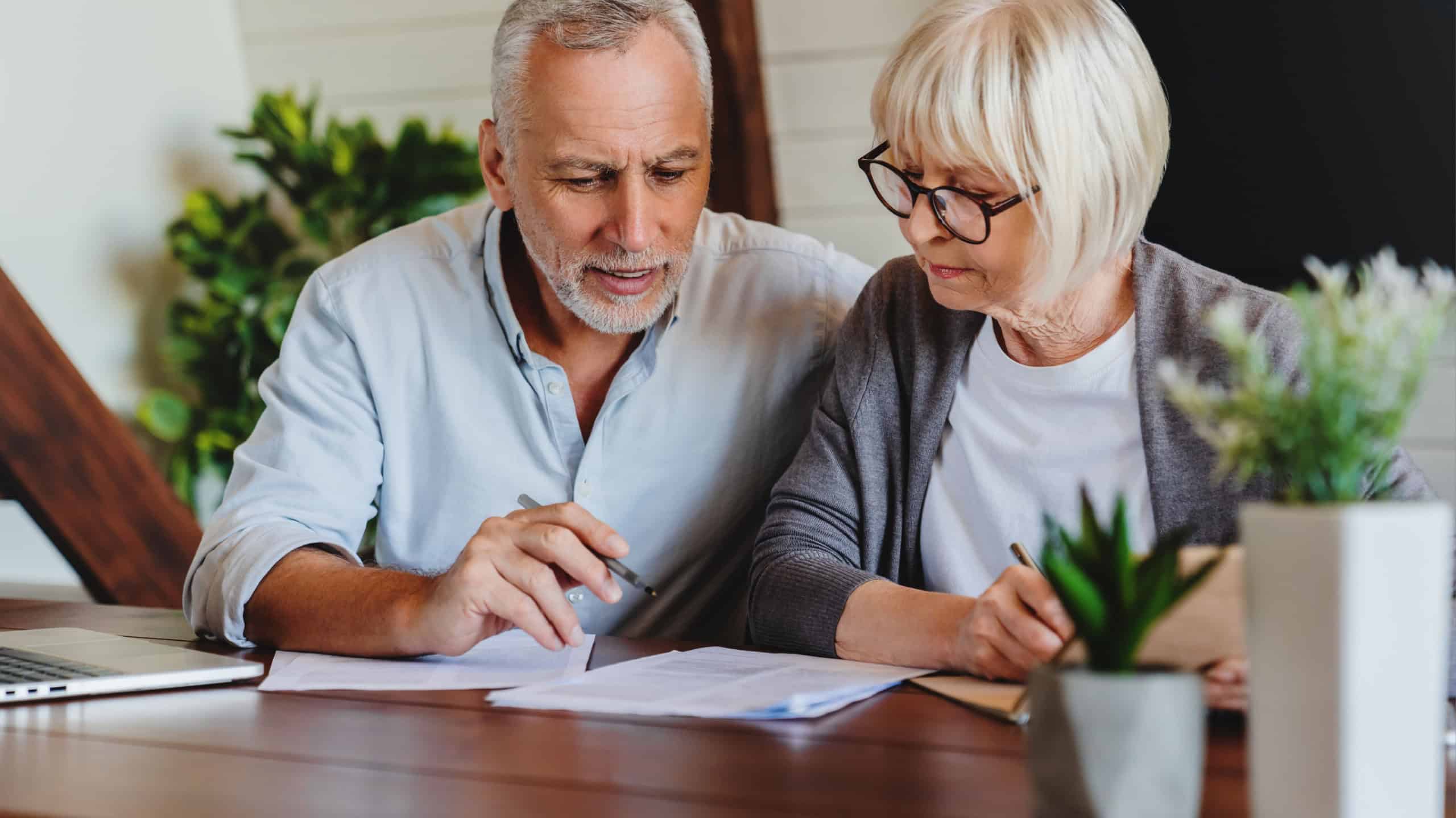 Excited elder family pensioner couple read and check financial document, calculate profit, saving income from investment. OAP Senior man and woman do monthly paperwork, make utility payment online