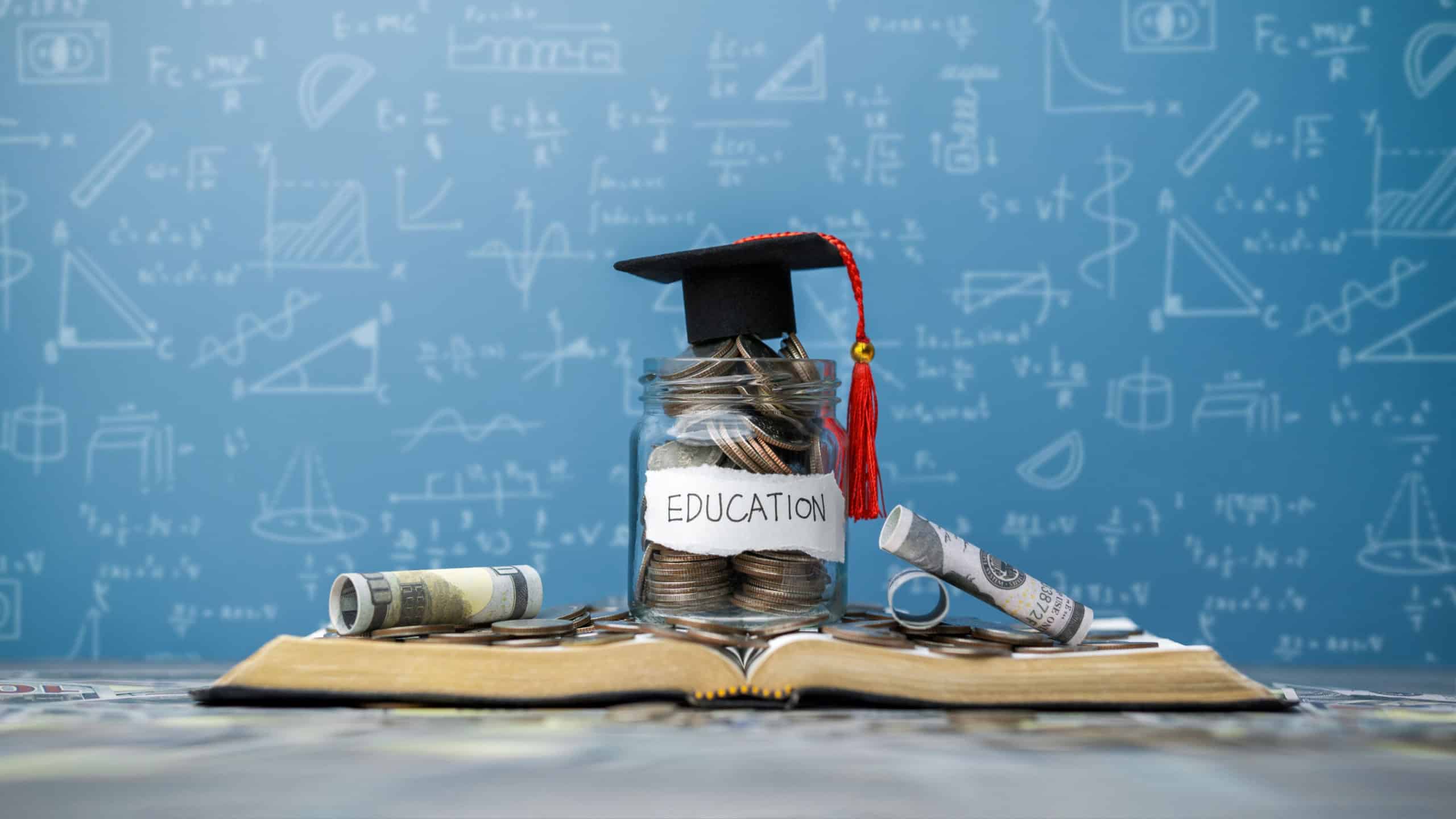 concept Student Success Scholarships, Students for College and University Tuition, Saving Money, Tuition for Education, Investment and Scholarships. Coins in a glass jar placed on a book