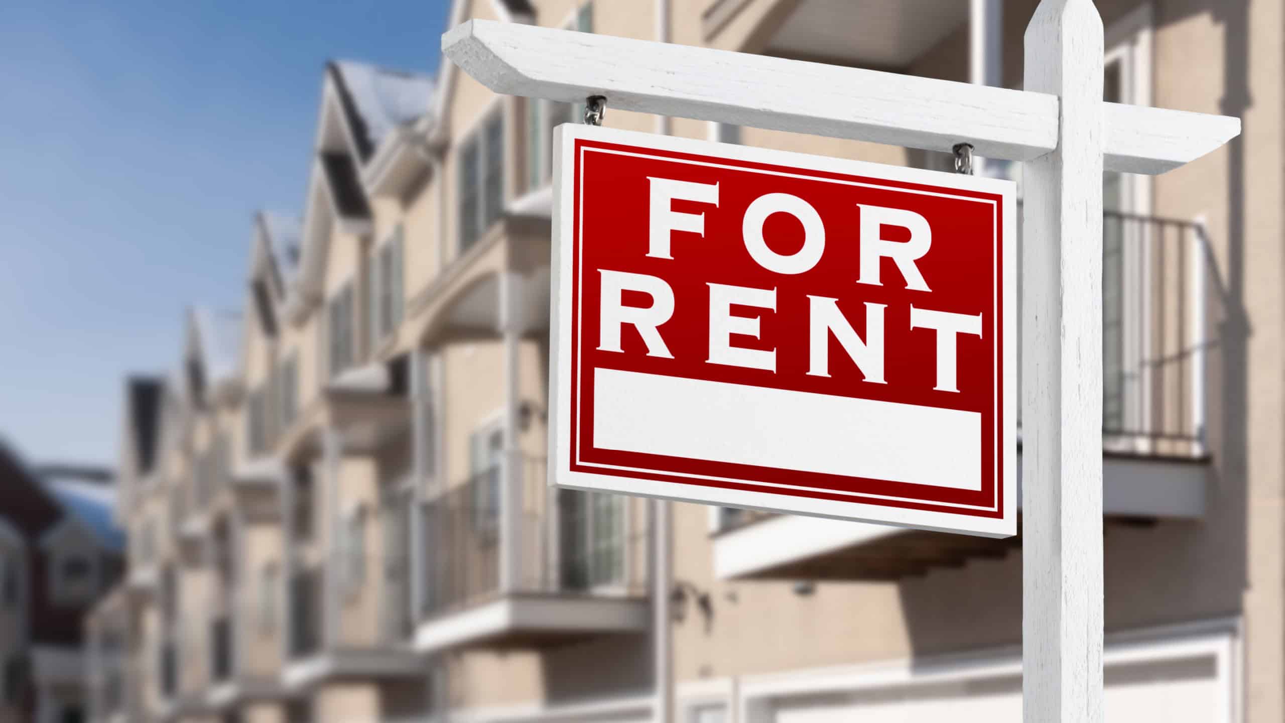 A "For Rent" sign outside of a residential building.
