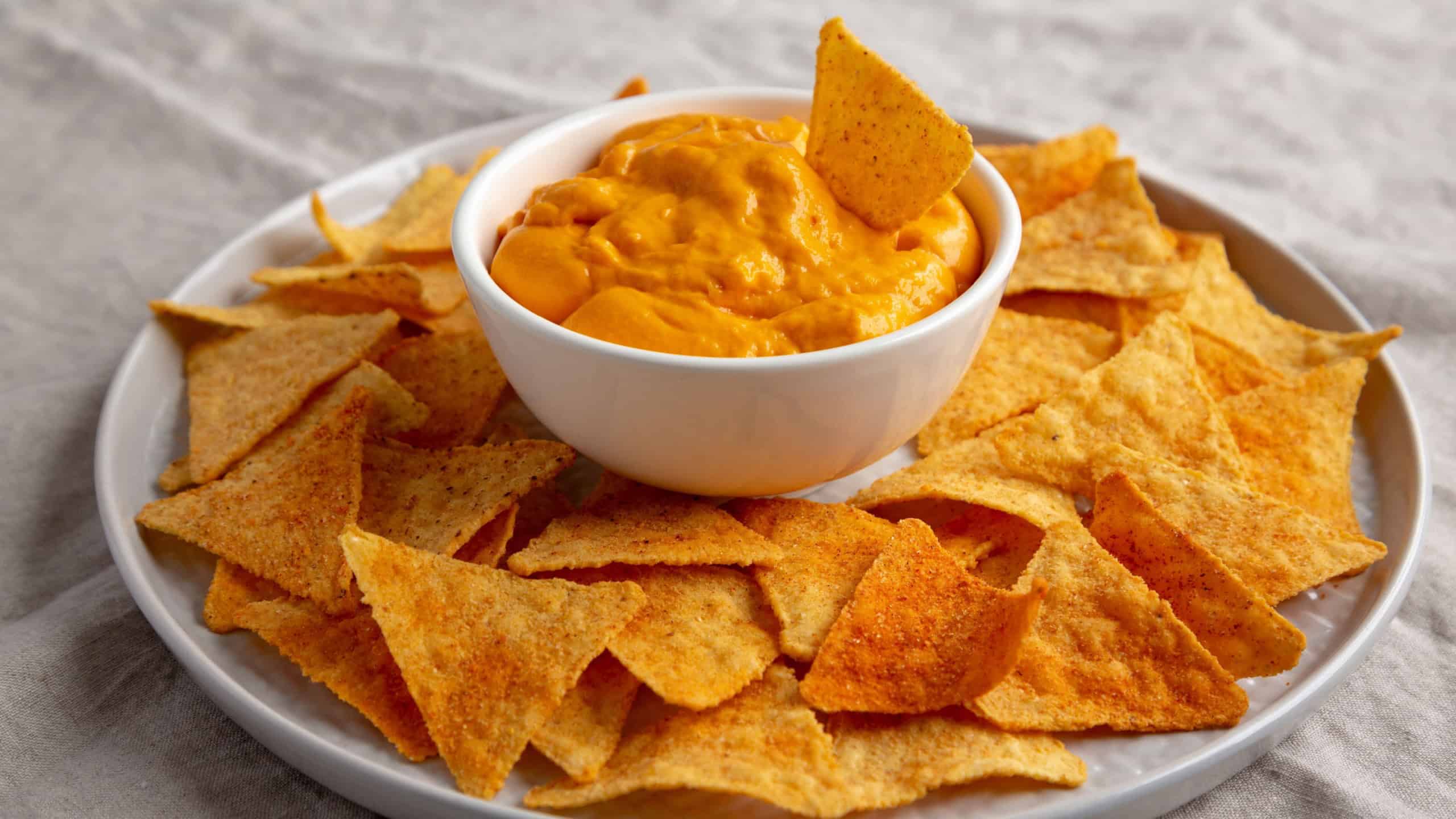Cheese dip with tortilla chips, side view.