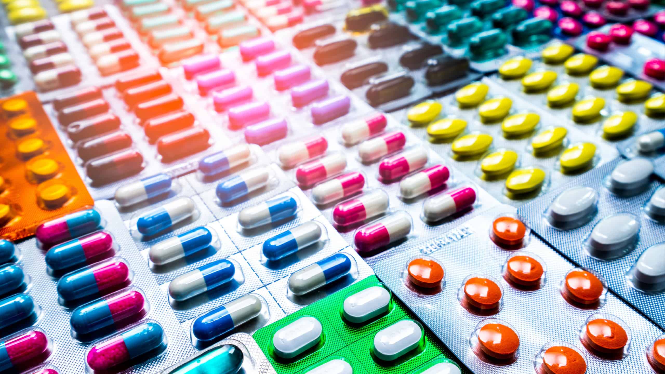 Colorful of tablets and capsules pill in blister packaging arranged with beautiful pattern with flare light. Pharmaceutical industry concept. Pharmacy drugstore. Antibiotic drug resistance.