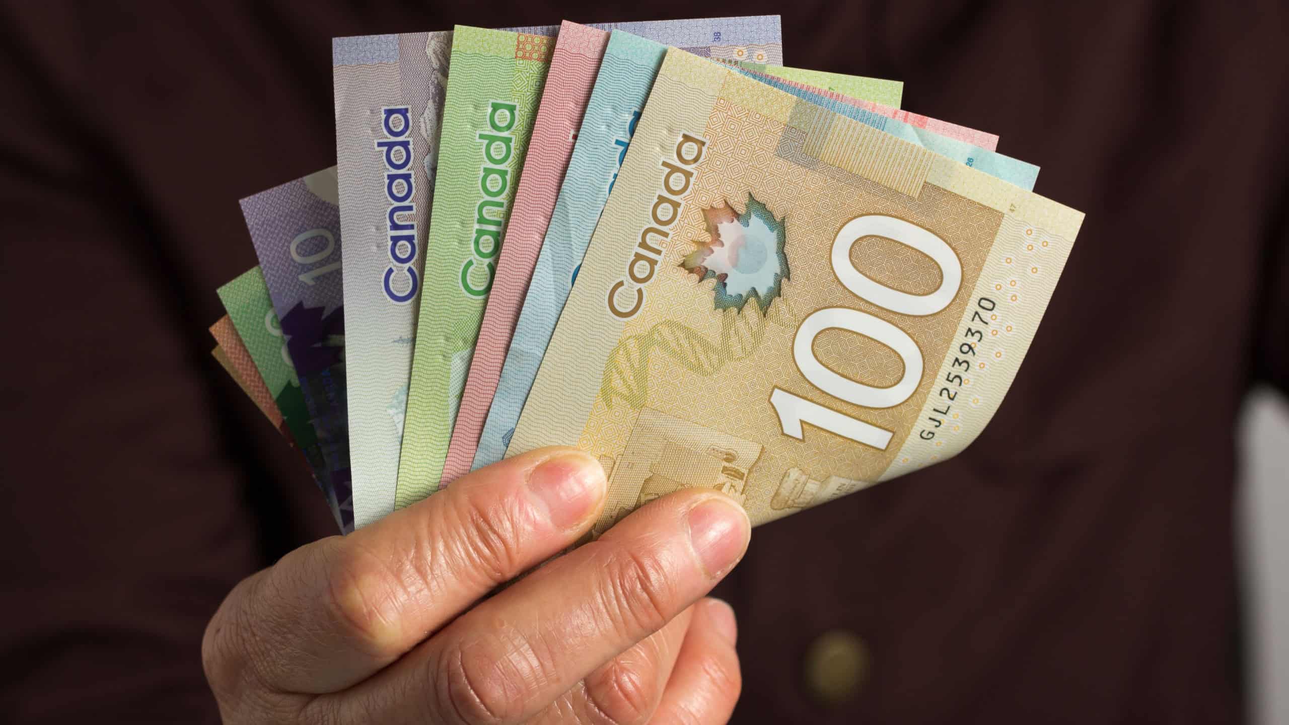 Money from Canada: Canadian Dollars. Old retired person paying in cash.
