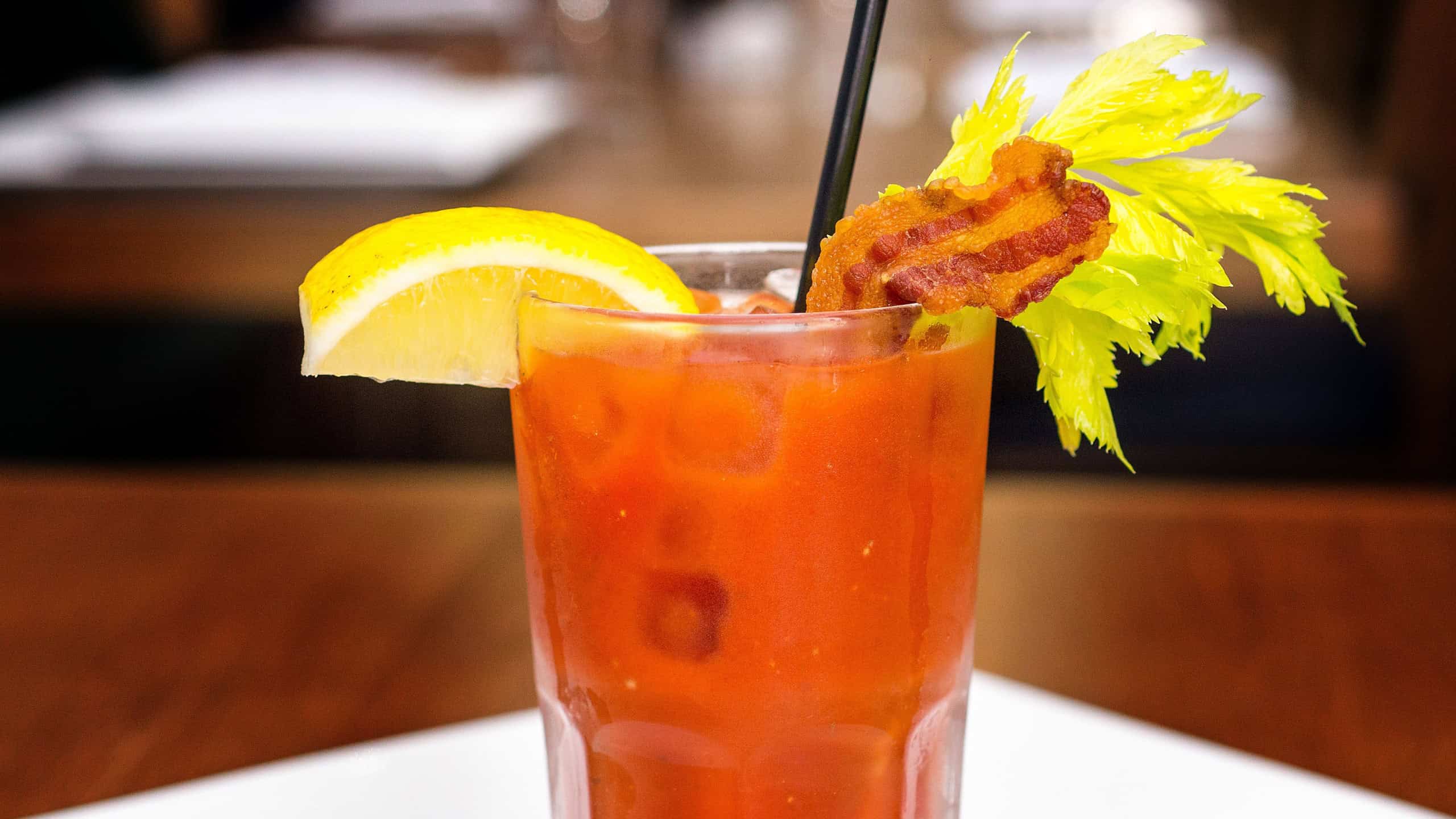 Bloody Mary or Caesar cocktail with bacon, lemon on restaurant background