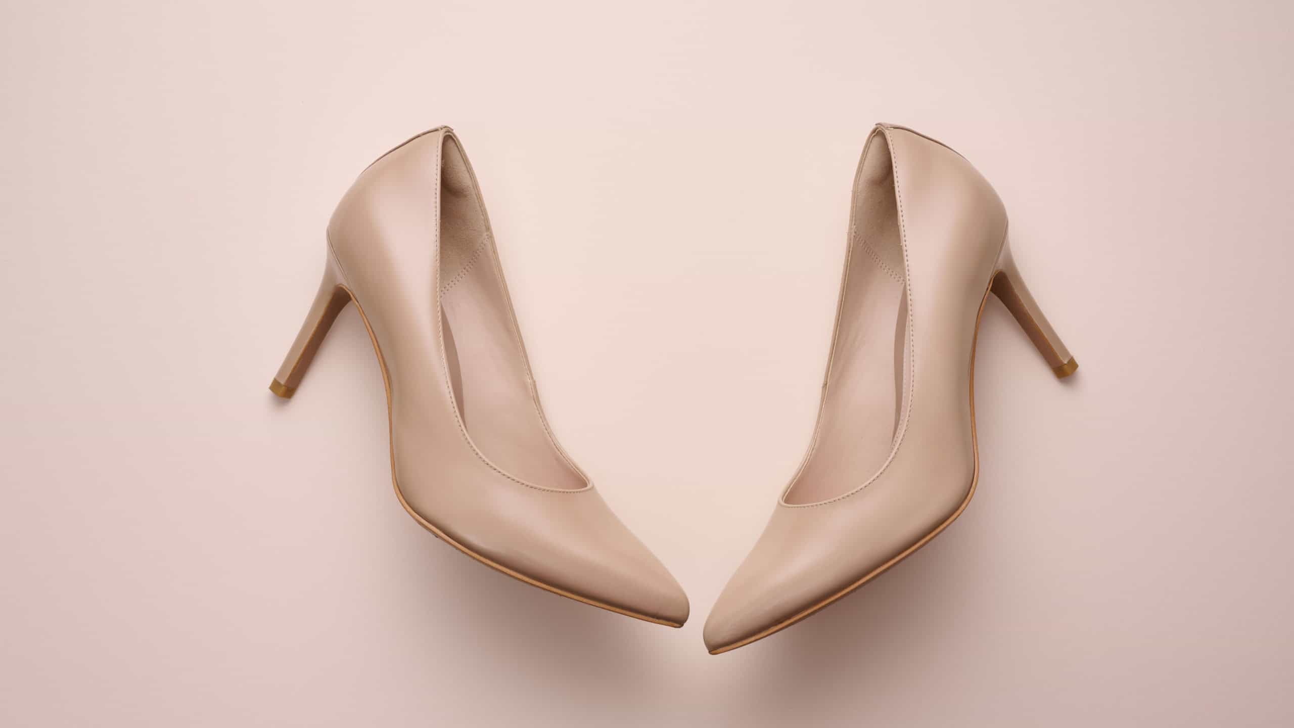 leather beige high heel shoes on a beige background, top view