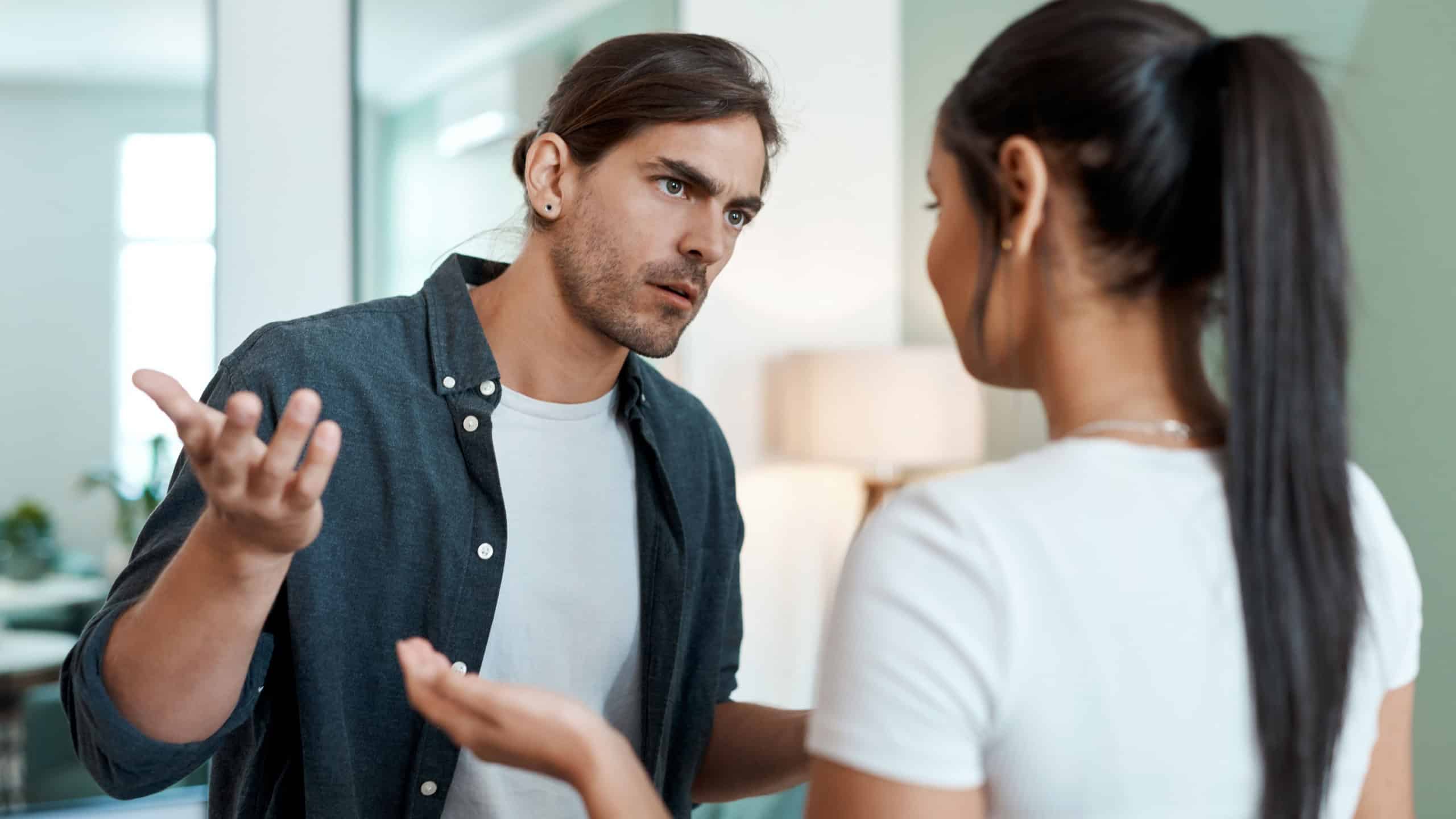 Argument, tension and couple in living room with fight, conflict or frustration in toxic relationship. Angry, man or woman in house with disagreement, confrontation or mistake in marriage crisis.