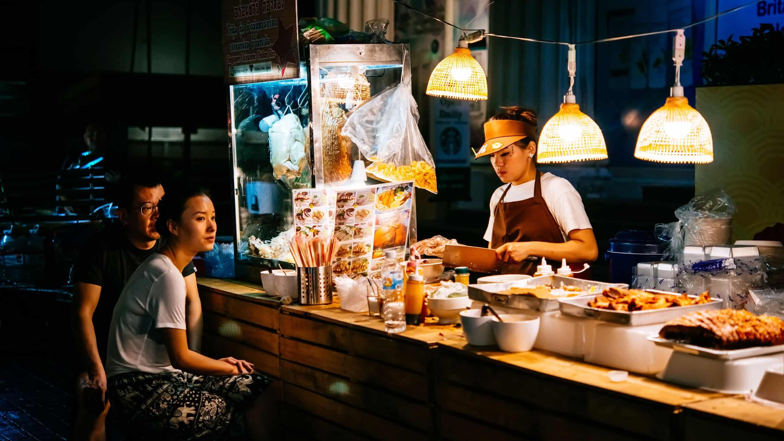 BANGKOK, THAILAND - FEBRUARY 26, 2016: People are buying food at night street food market in Bangkok, Thailand.