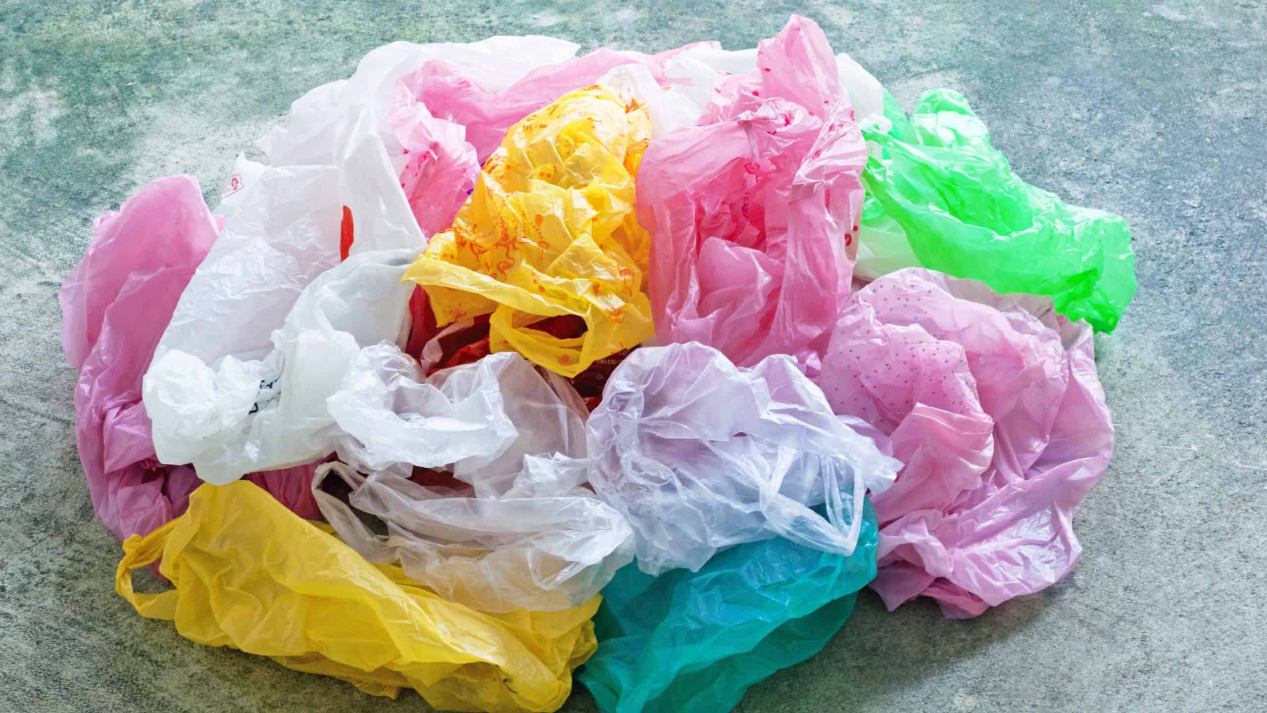 Colorful plastic bags on cement floor background.