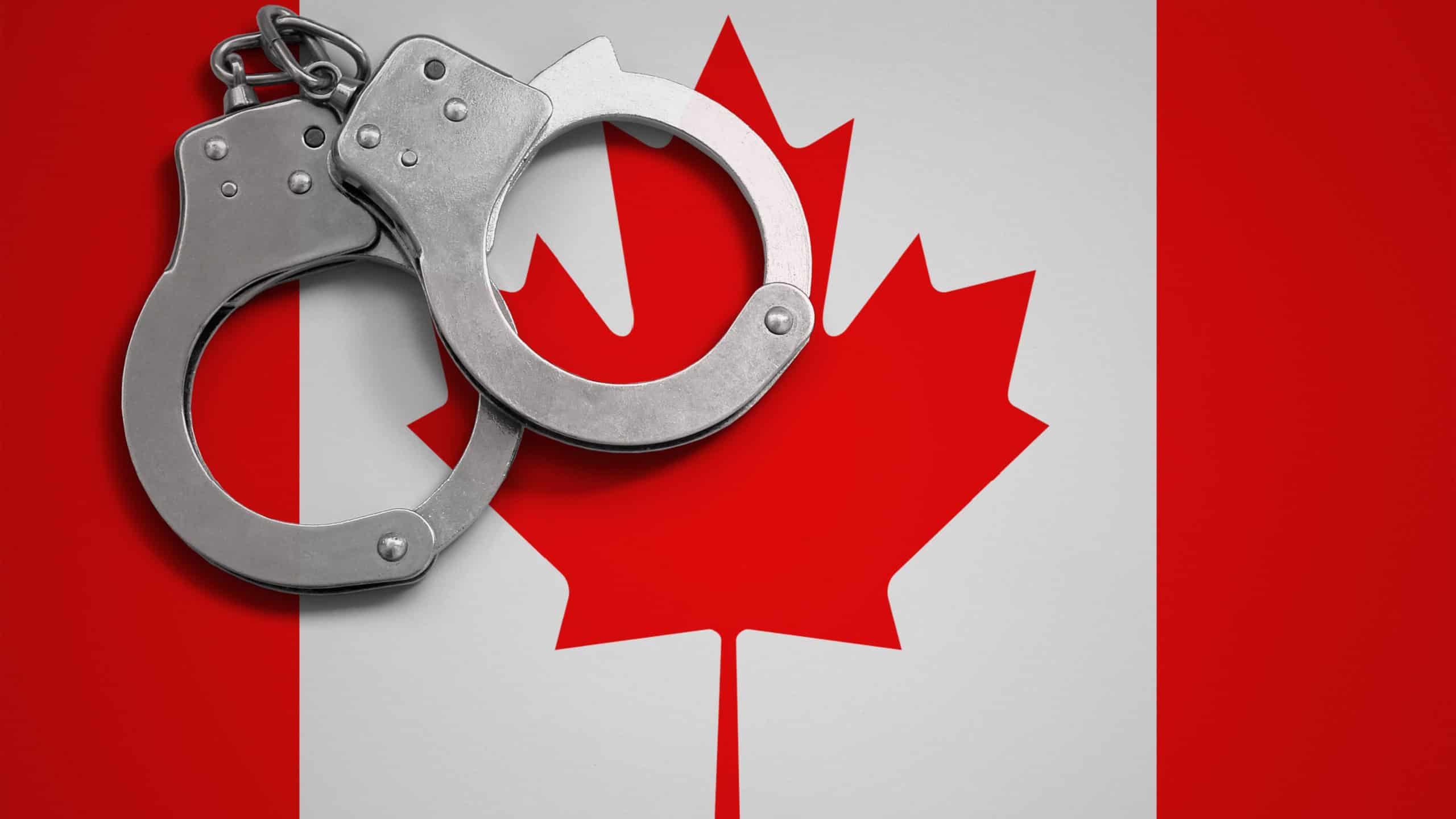 Canada flag and police handcuffs. The concept of crime and offenses in the country