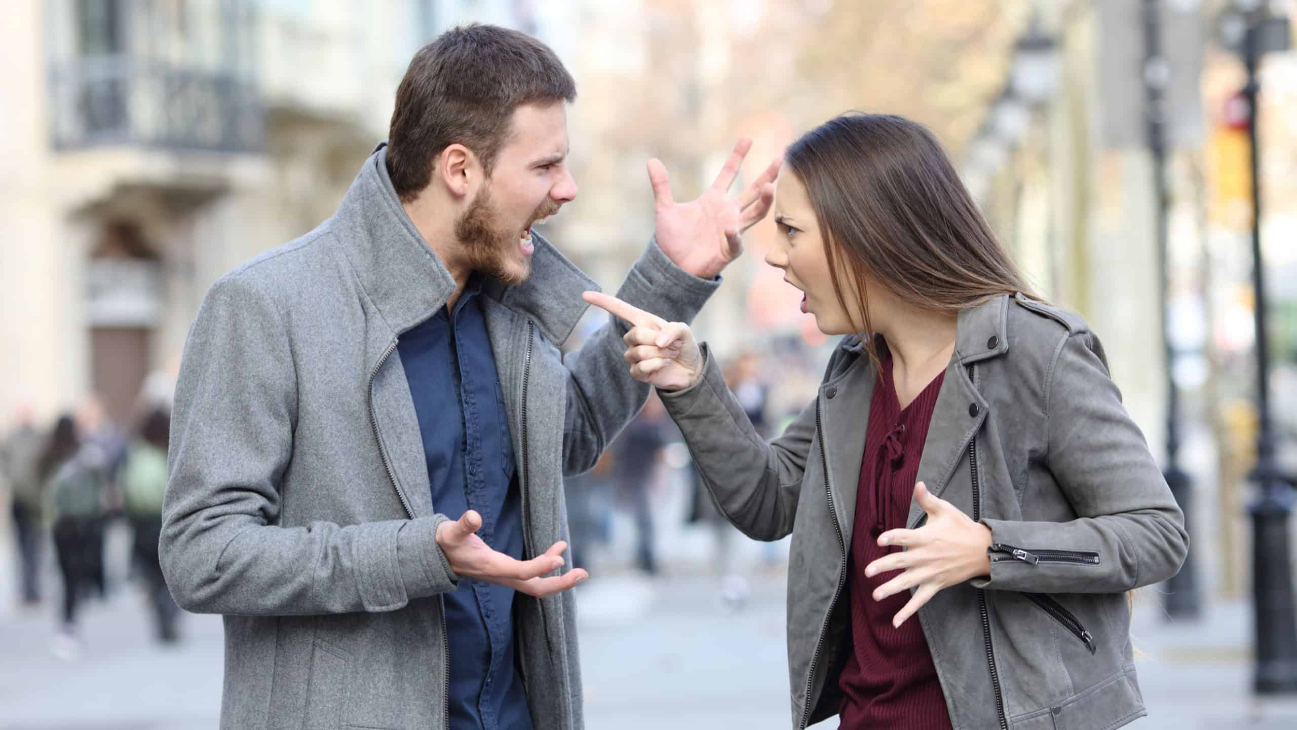 Angry couple arguing in the middle of a city street
