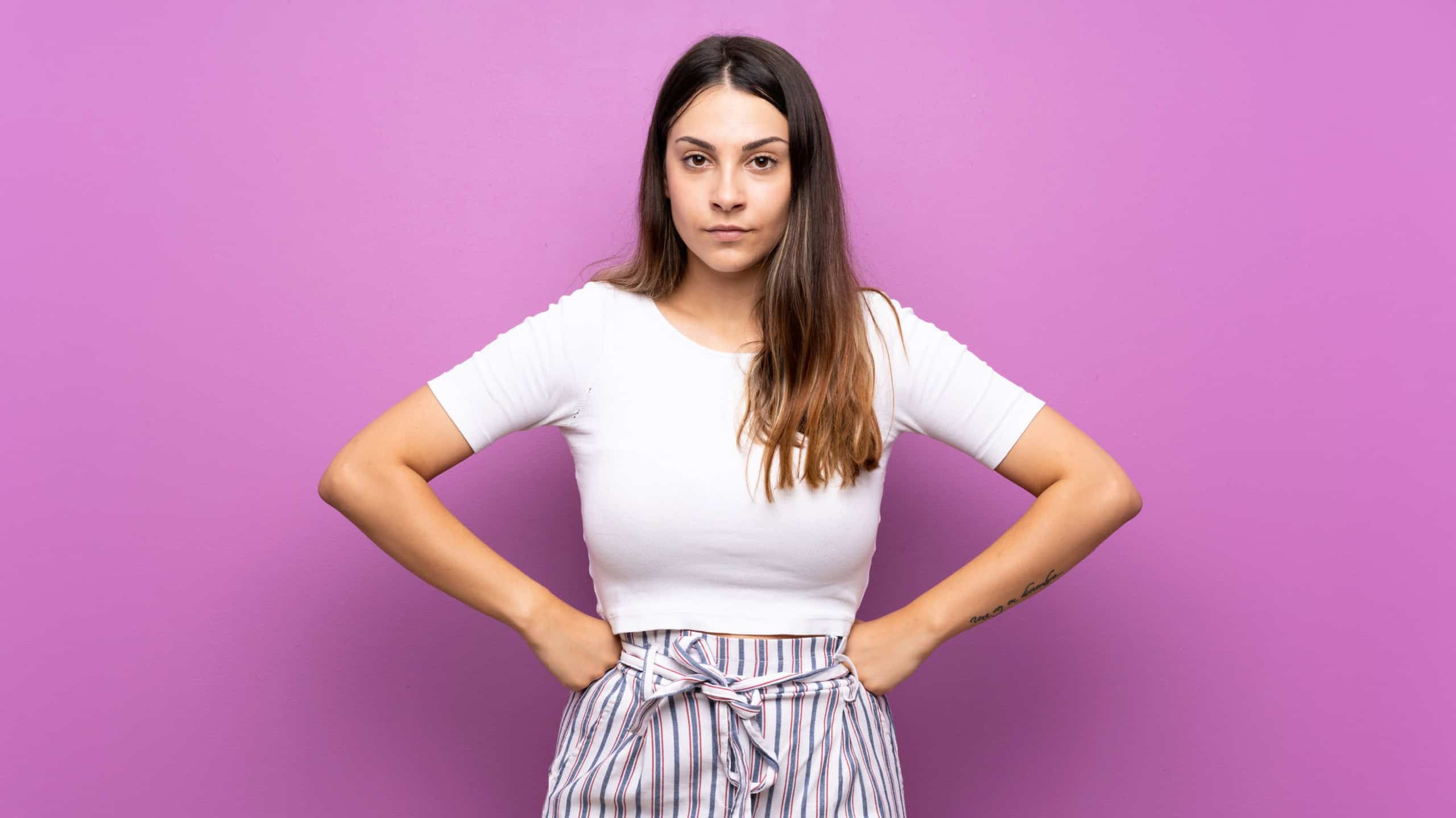 Young woman over isolated purple background angry