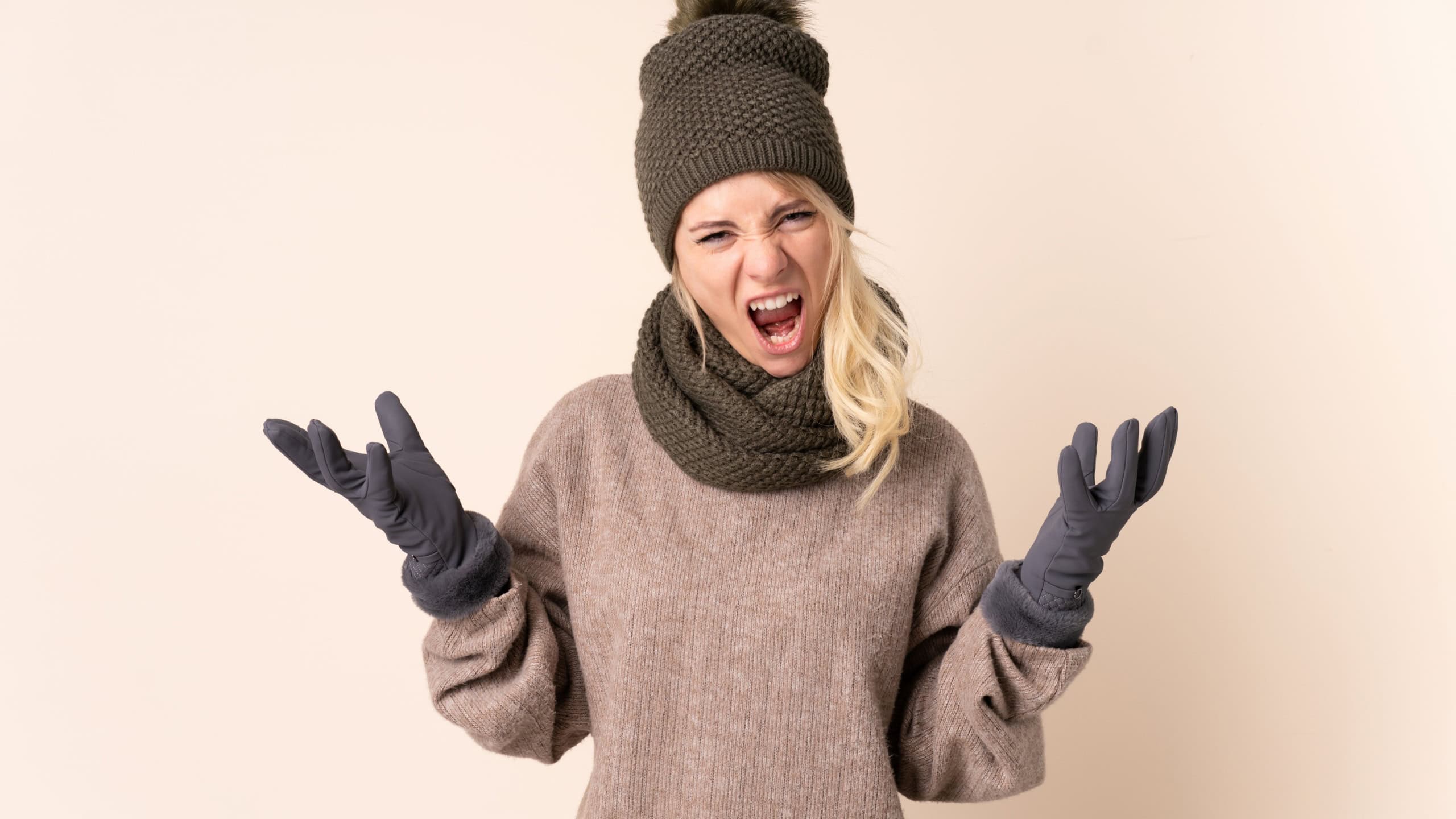 Young woman with winter hat over isolated background unhappy and frustrated with something