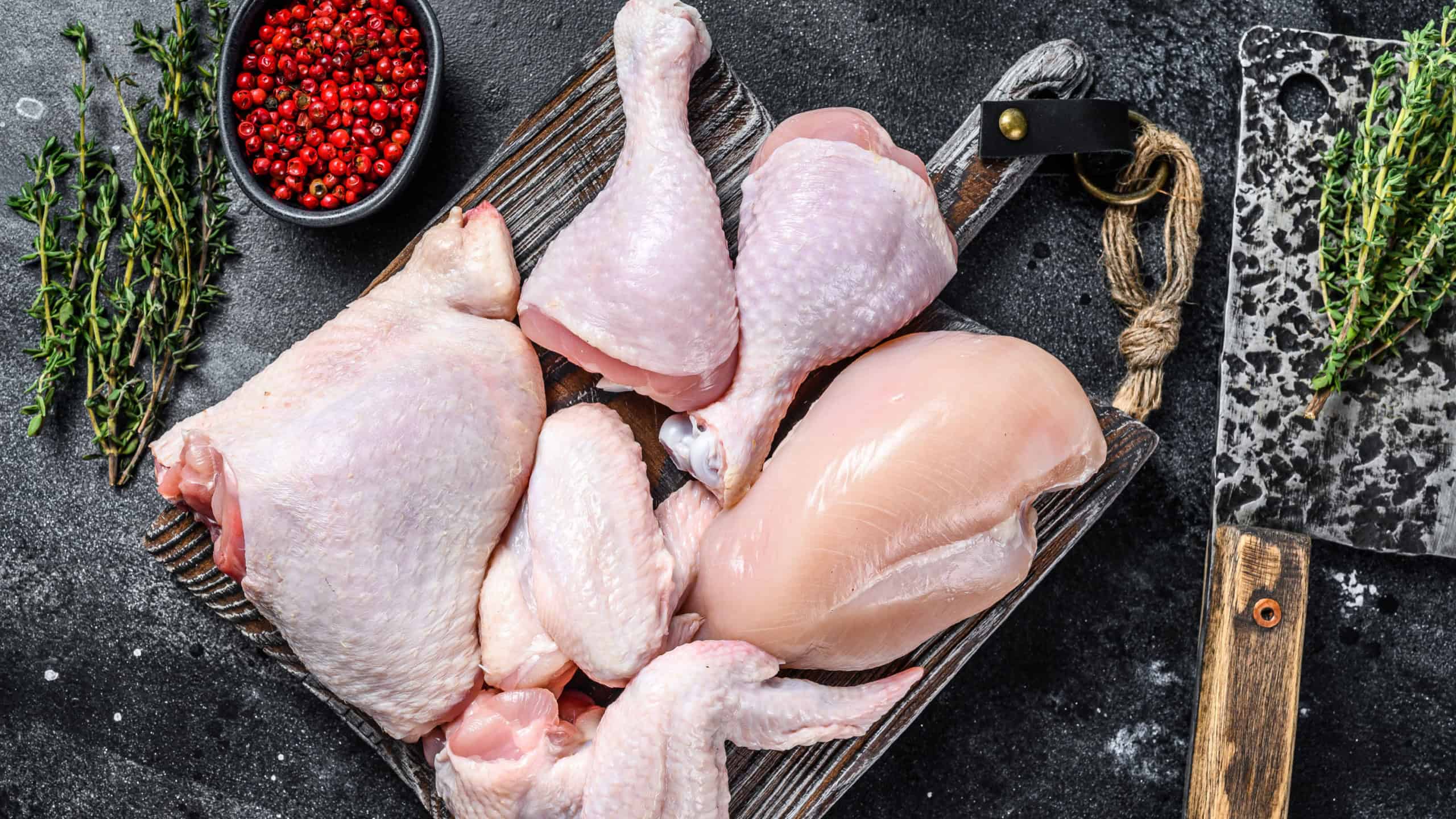 Fresh raw chicken meat, wings, breast, thigh and drumsticks. Black background. Top view.