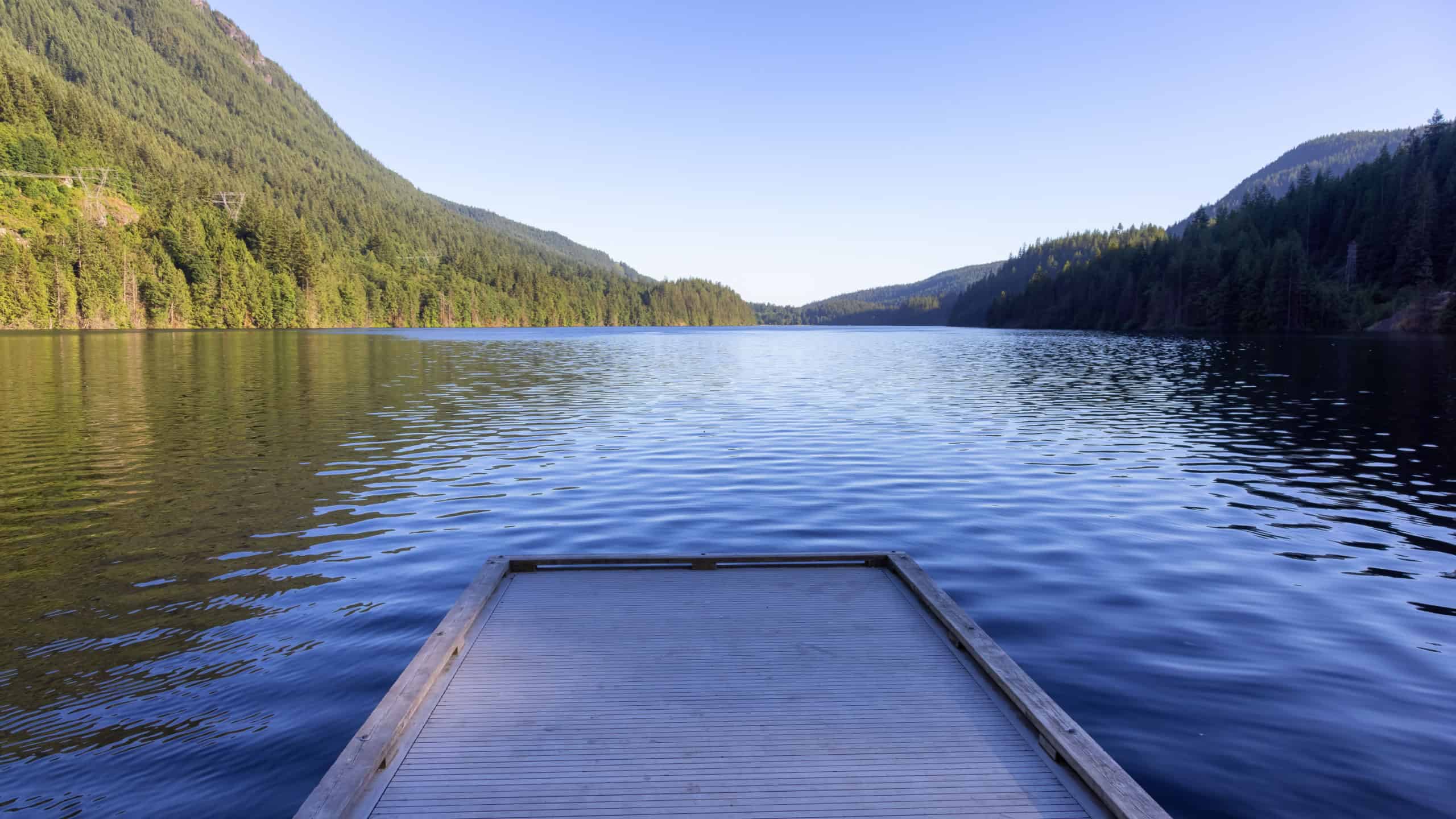 View of Buntzen Lake surrounded by Canadian Mountain Landscape. Sunny Summer Evening. Located in Anmore, Vancouver, British Columbia, Canada. Nature Background