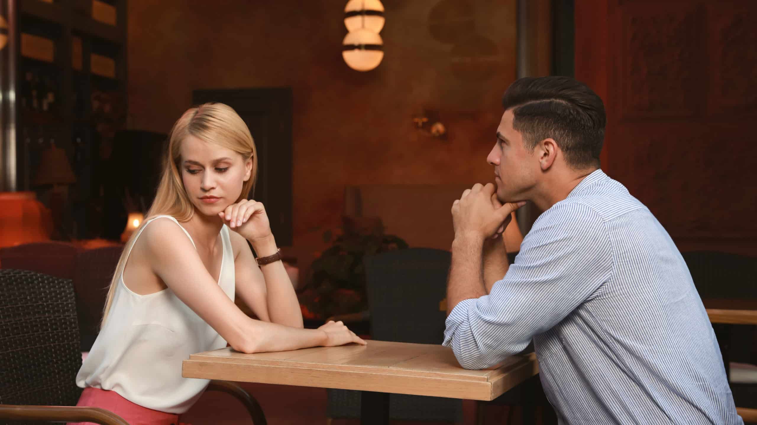Bored couple having unsuccessful date in cafe