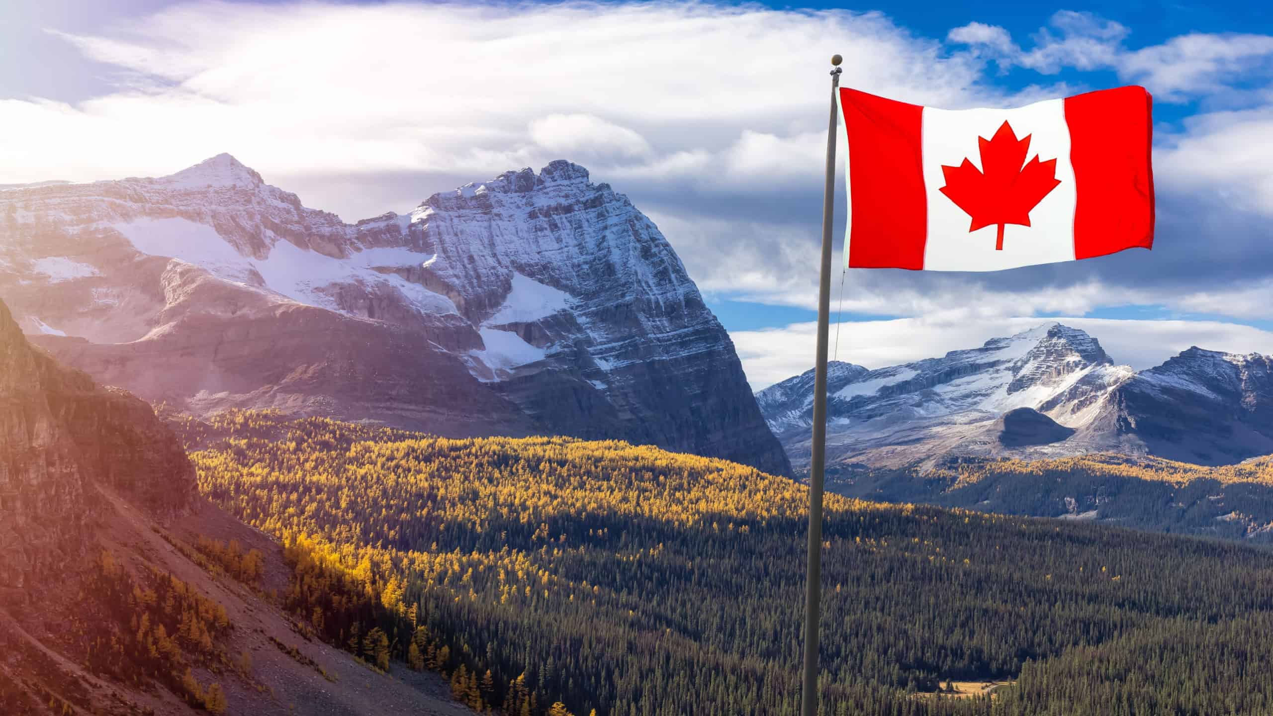 Canadian National Flag Composite with Canadian Rocky Mountains in Background. Sunny Fall Day. Located in Lake O'Hara, Yoho National Park, British Columbia, Canada.