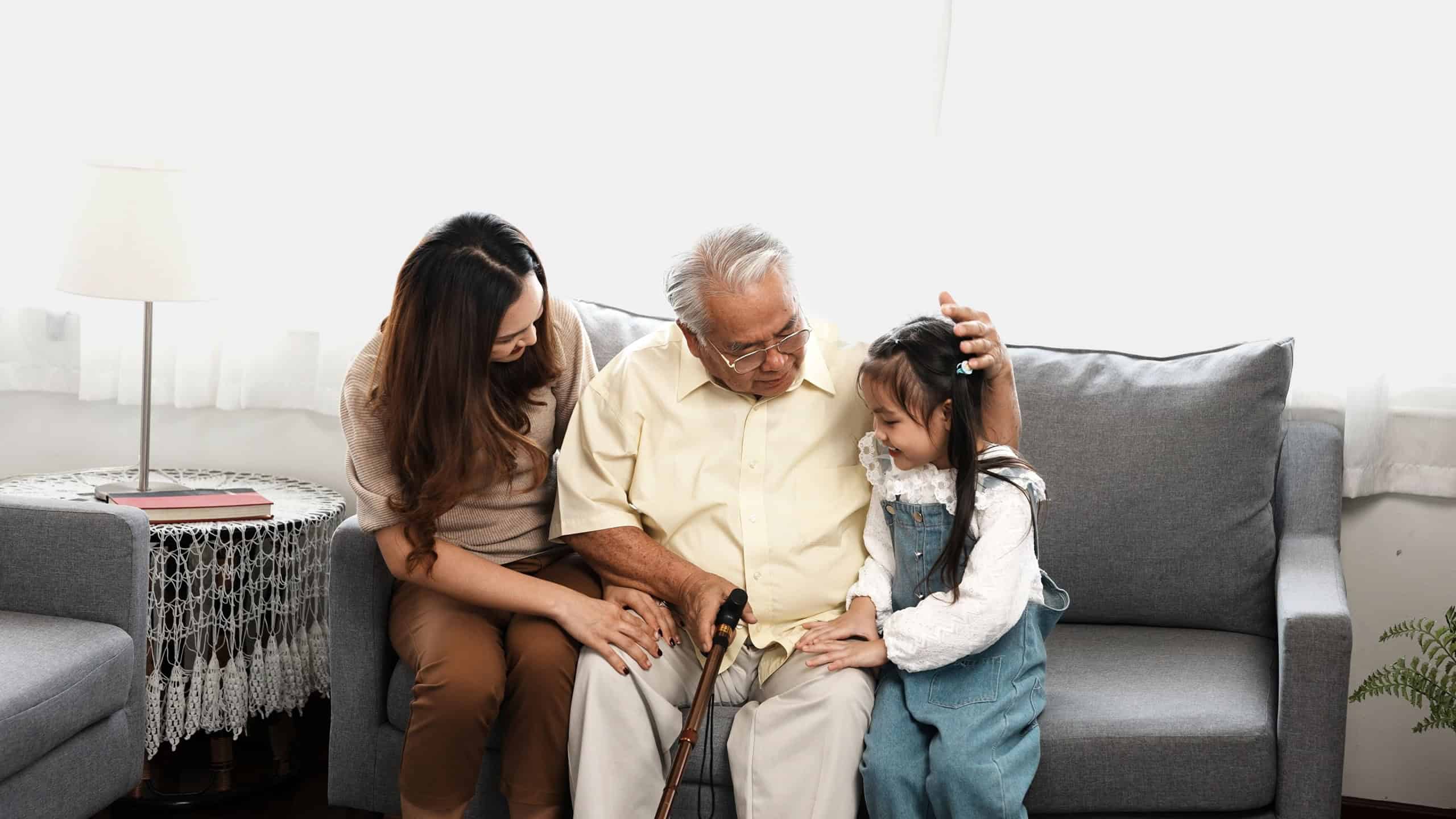 Asian family, Daughter and granddaughter take care support senior mature grandfather who is suffering from knee pain walking outside to take a walk And grandpa with a stick, elderly health care