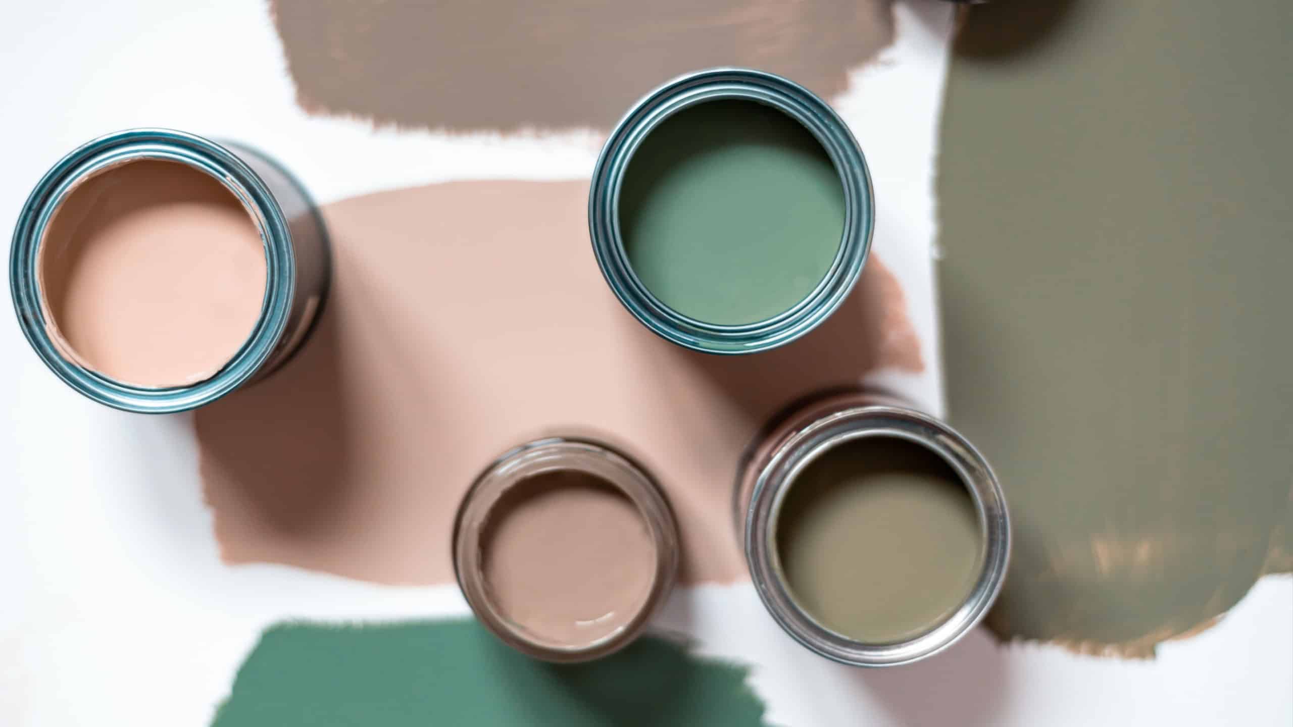 Tiny sample paint cans during house renovation, process of choosing paint for the walls, different green colors, color charts on background