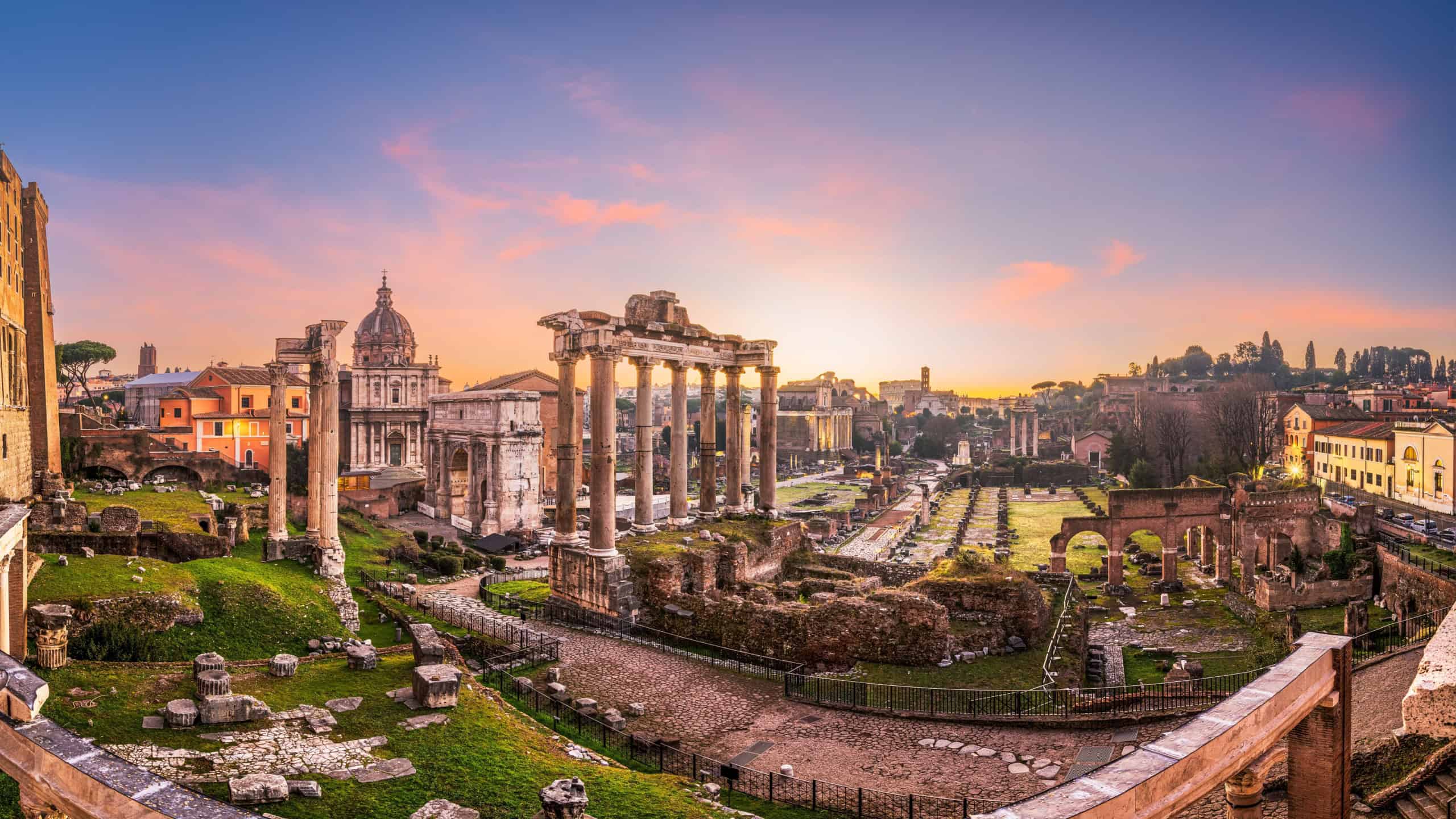 Rome, Italy at the historic Roman Forum ruins at dusk.