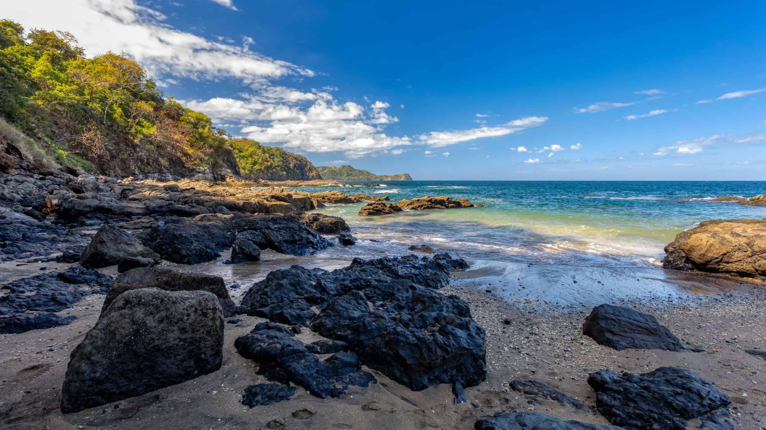 Playa Ocotal with Pacific ocean waves on rocky shore, El Coco Costa Rica. Famous snorkel beach. Picturesque paradise tropical landscape. Pura Vida concept, travel to exotic tropical country.