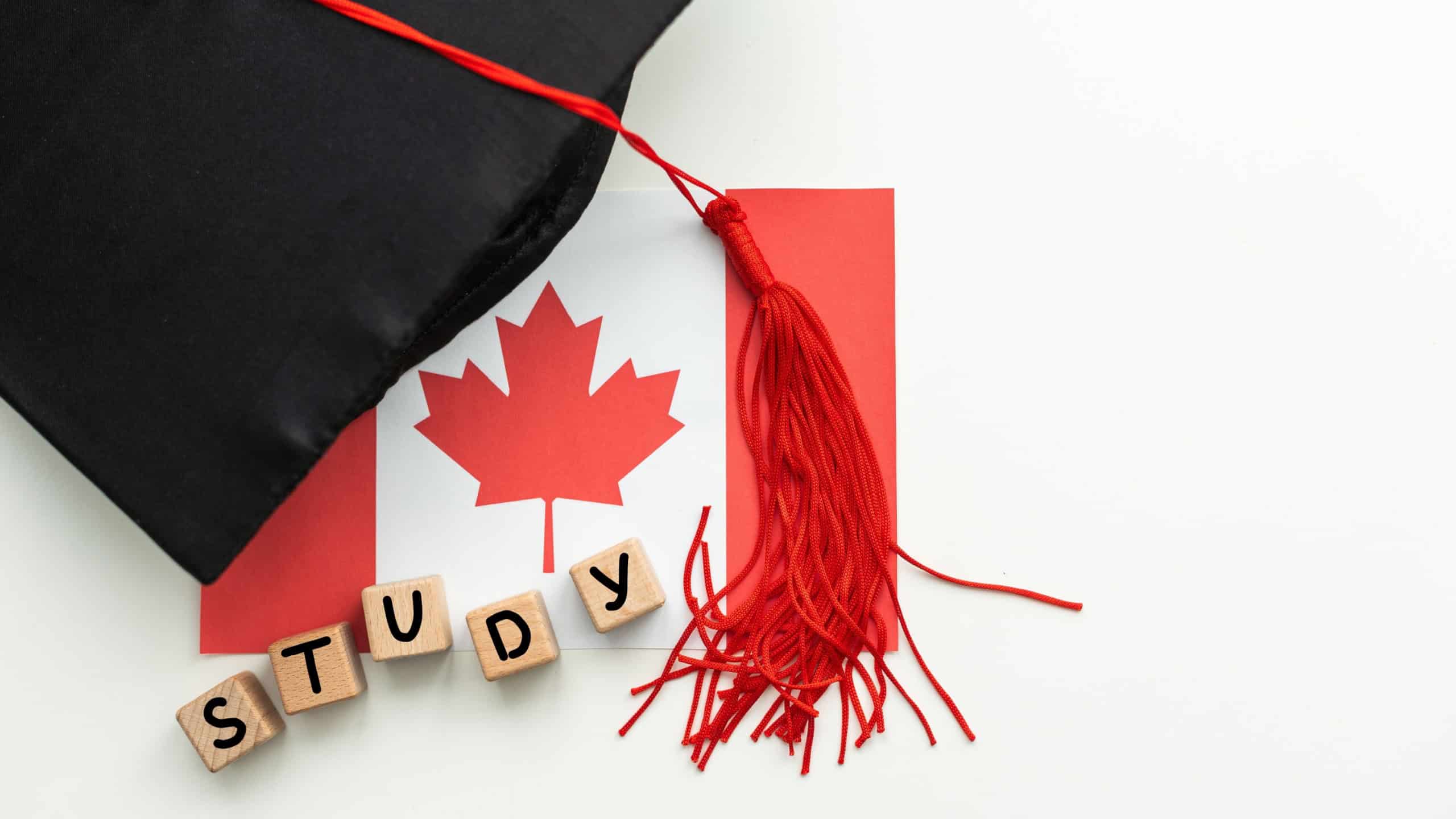 Canadian education. Graduate diploma and academic hat against the background of the flag of Canada.