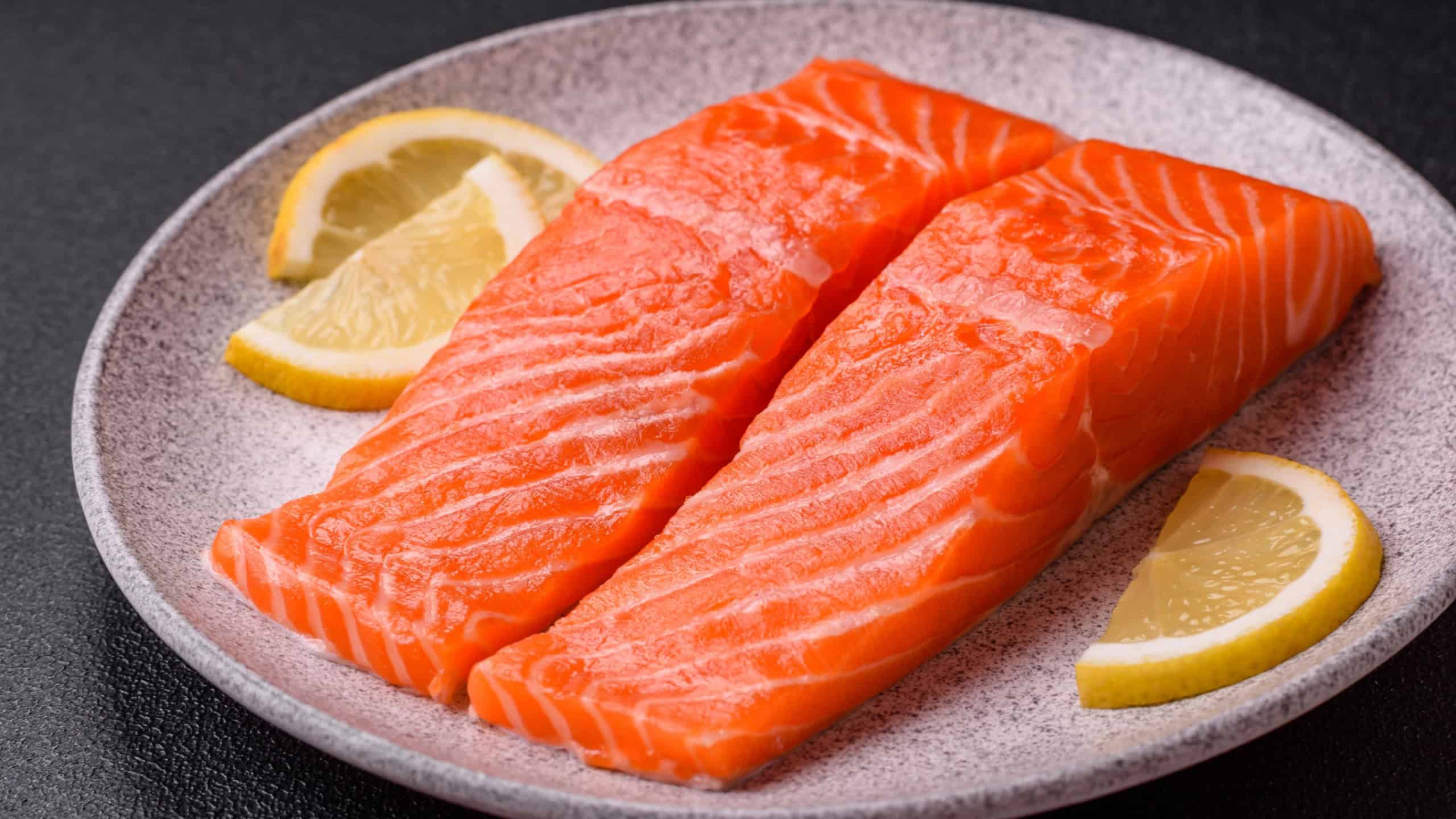 Fresh raw salmon steak with spices and herbs prepared for grilled baking. Healthy seafood food