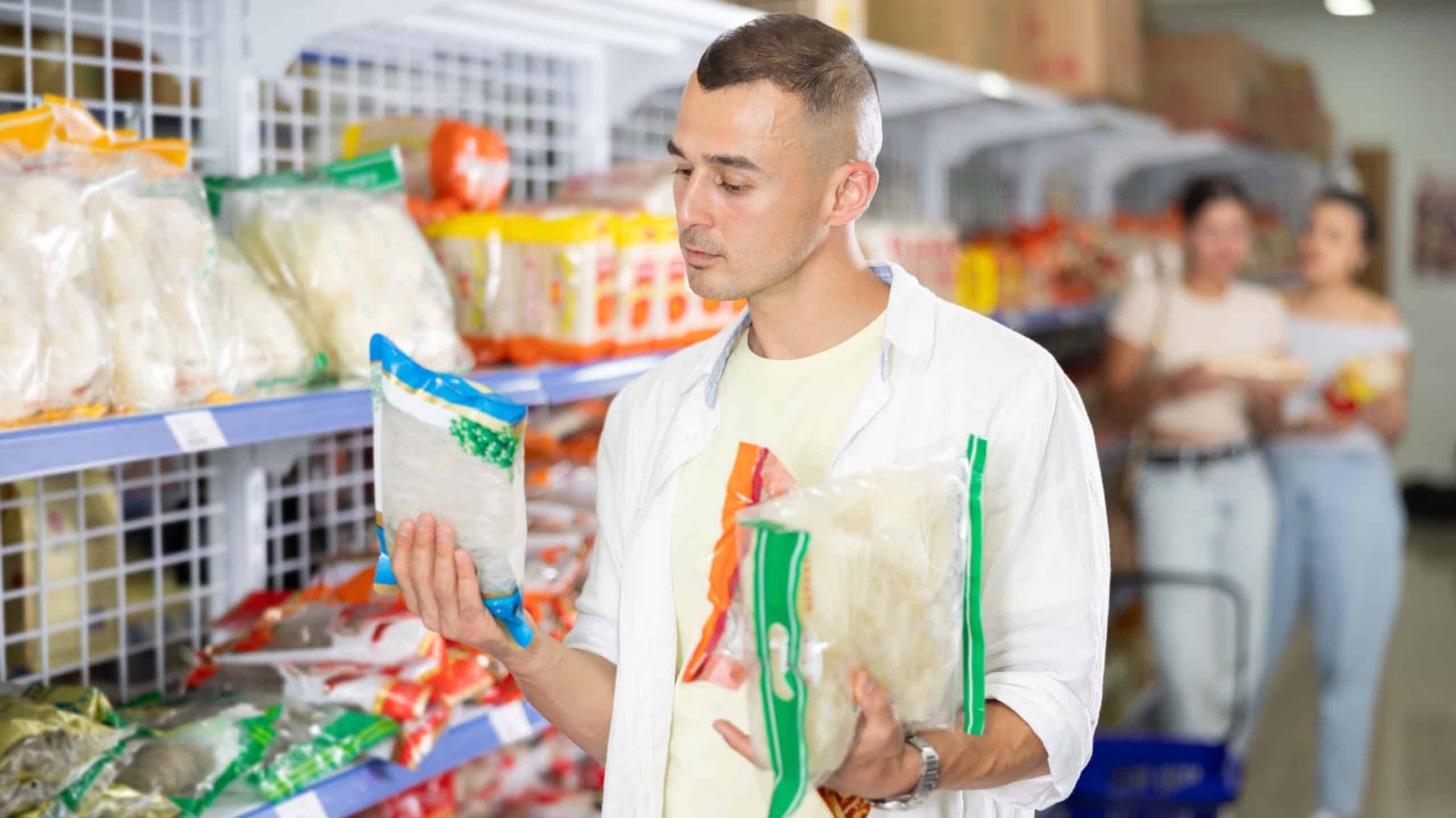 Male shopper choosing traditional Chinese noodles in a supermarket