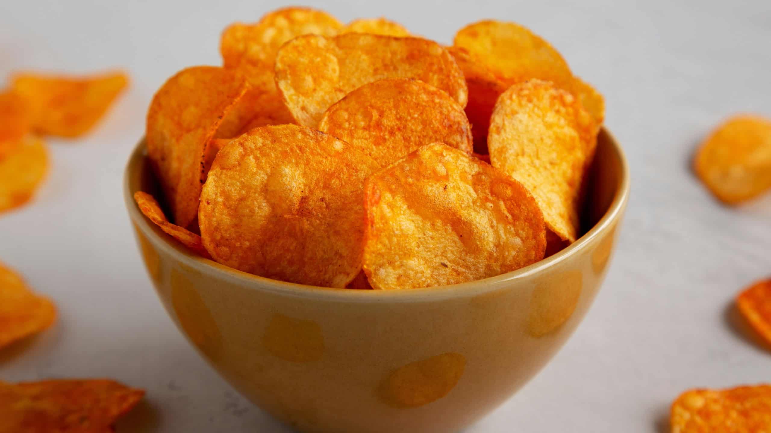 Homemade Flavored Paprika Potato Chips in a Bowl, side view. Close-up.