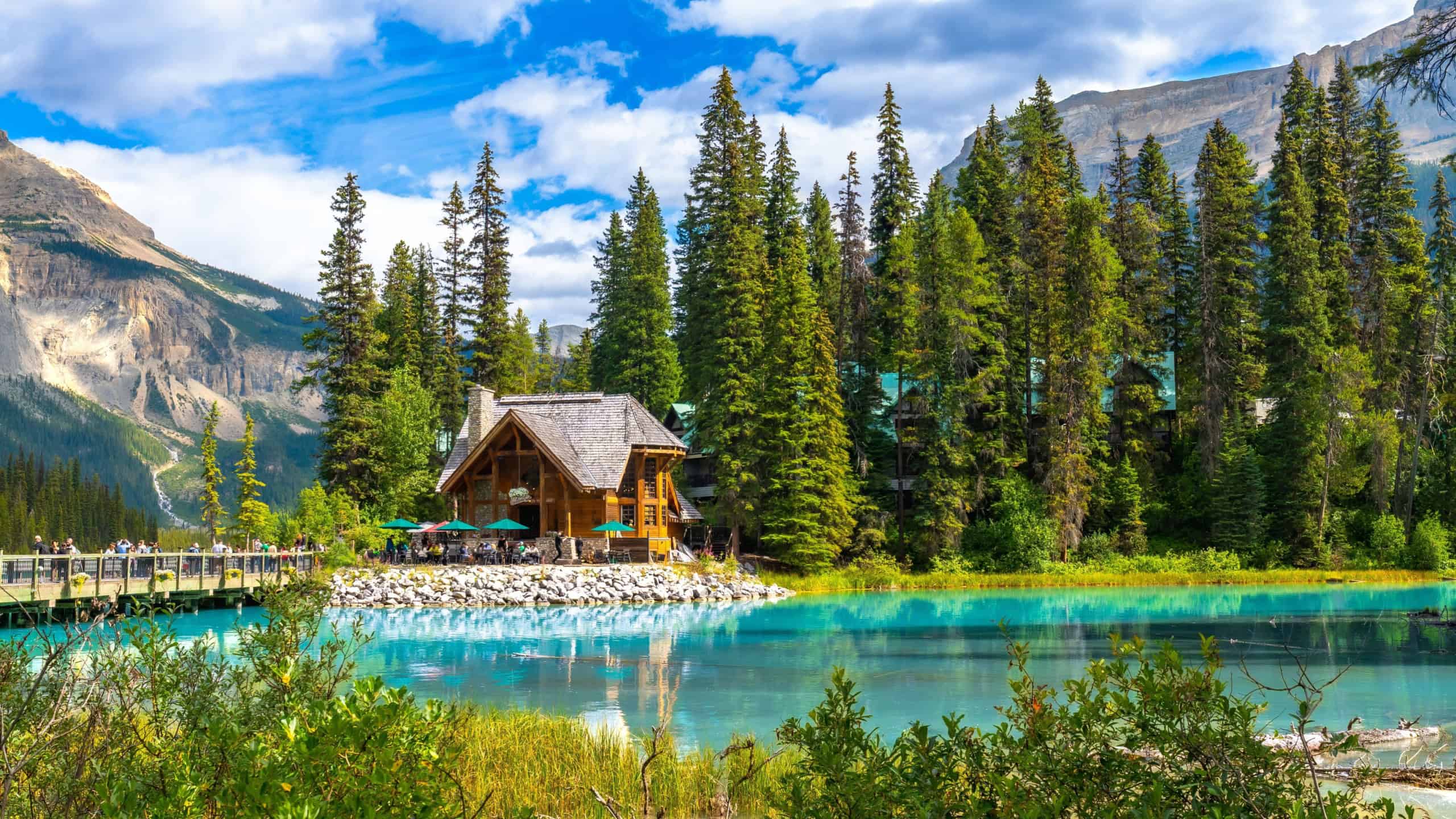 Emerald lake lodge with surrounding pine trees reflecting in the turquoise water of emerald lake in yoho national park, british columbia, canada, on a beautiful summer day