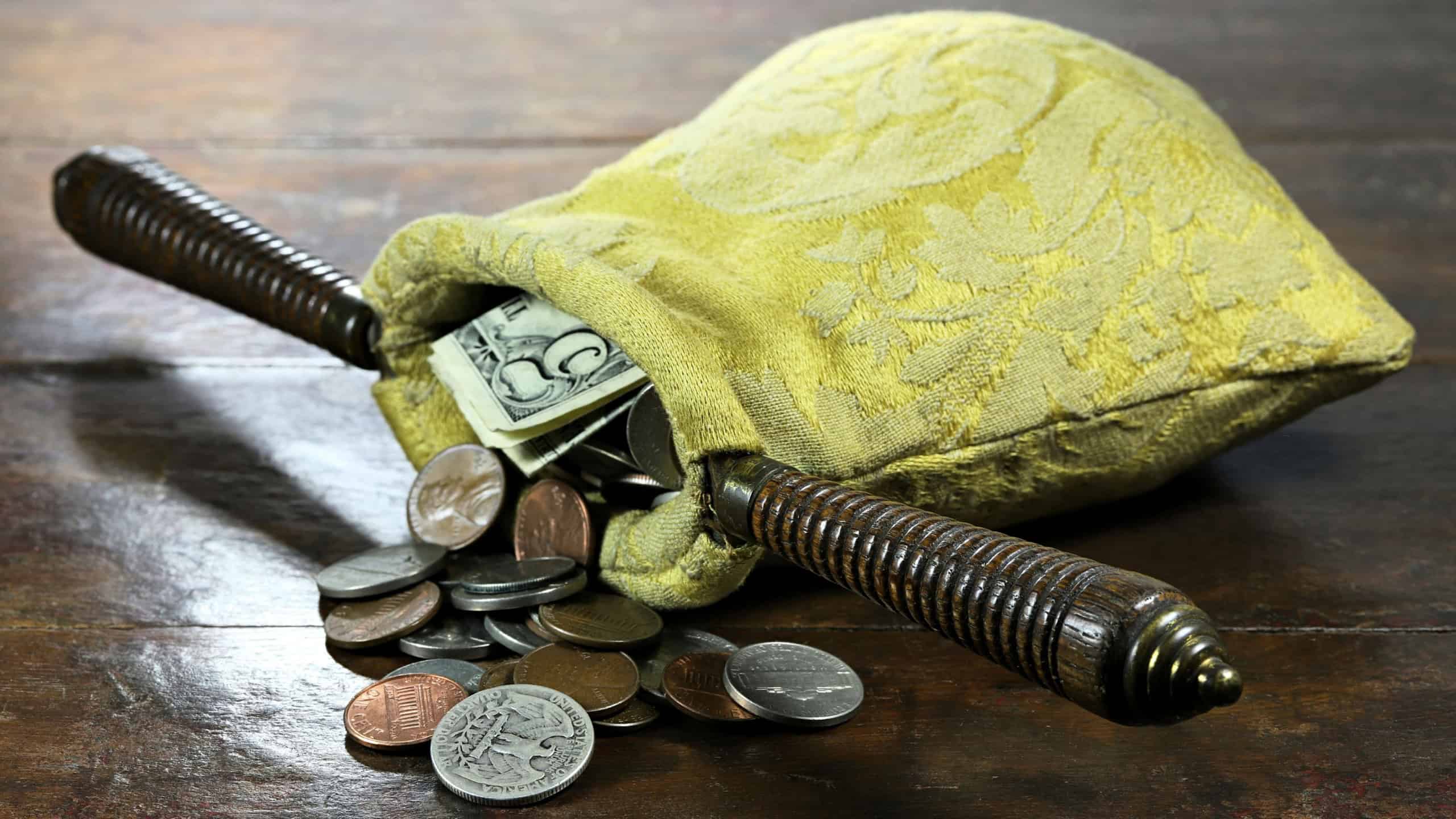 collection bag filled with US Coins on rustic wooden background