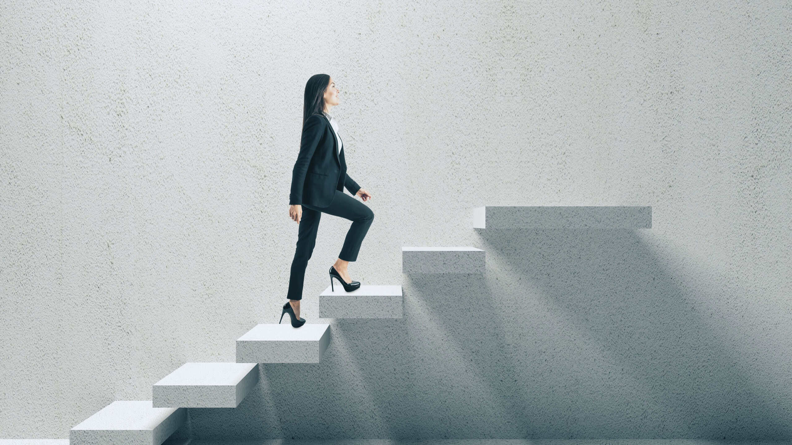 Side view of young businesswoman climbing concrete stairs. Career development and success concept.