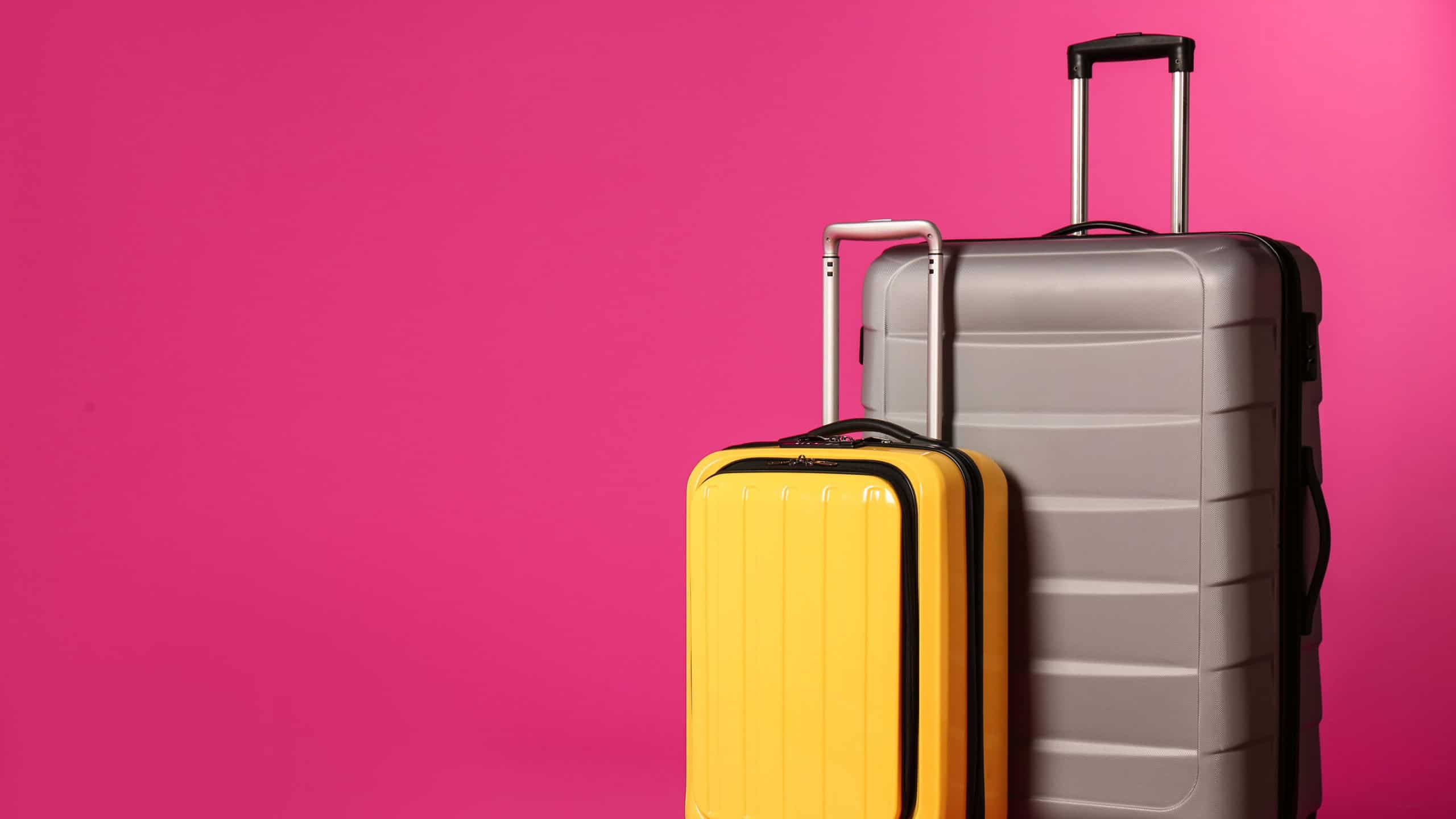 Stylish suitcases on color background. Space for text