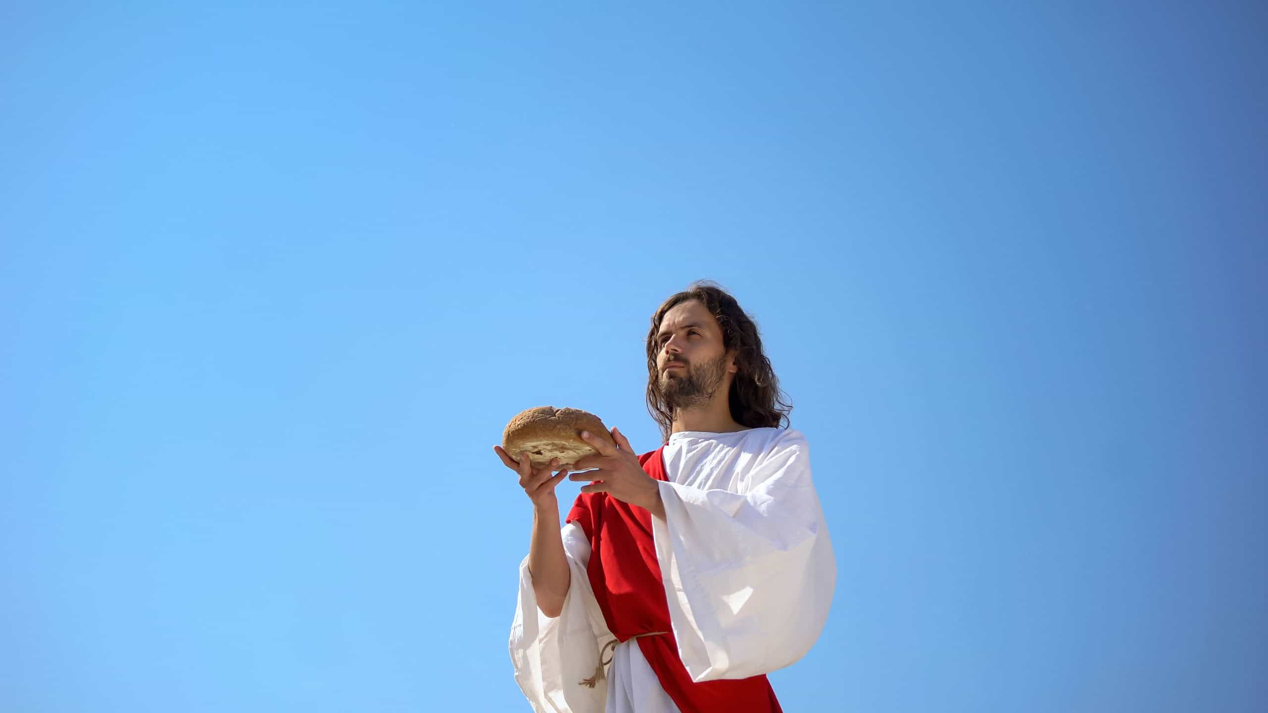 Preacher holding bread, blessing sacramental food, Lord's Supper concept