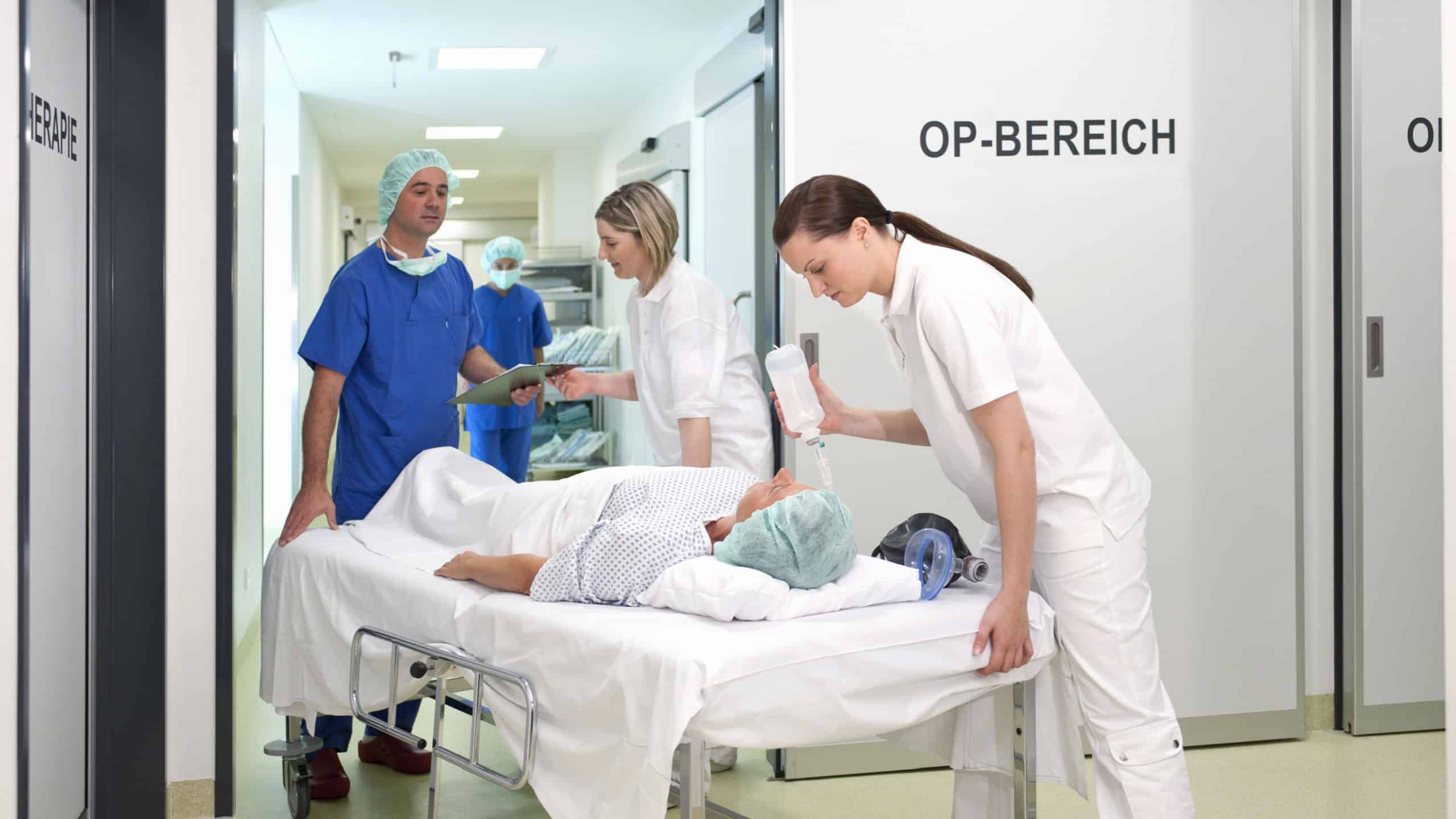 Doctor and nurses taking patient into operating room at hospital