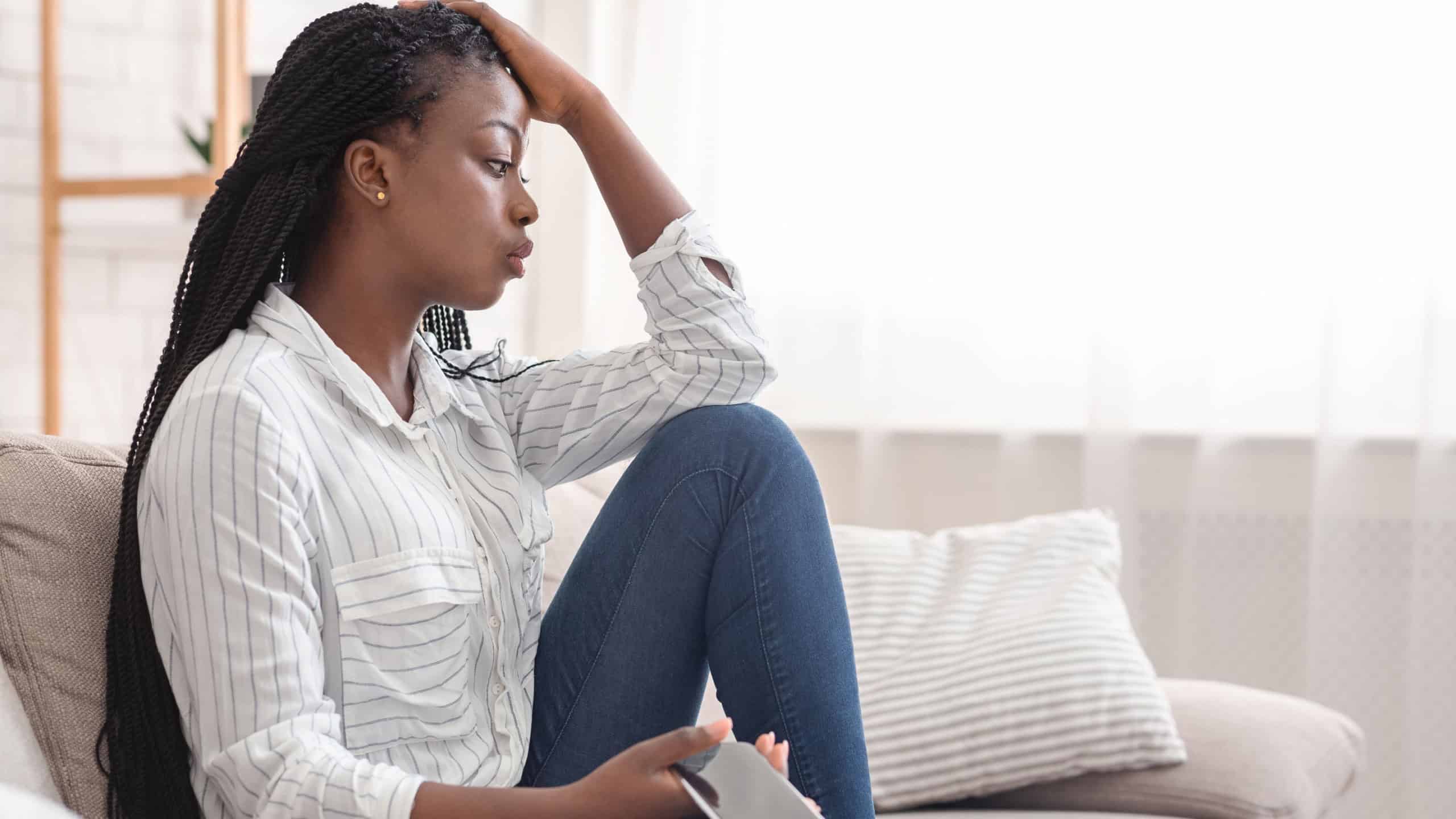 Upset Afro Girl Waiting For Important Call, Sitting On Couch With Cellphone At Home, Free Space