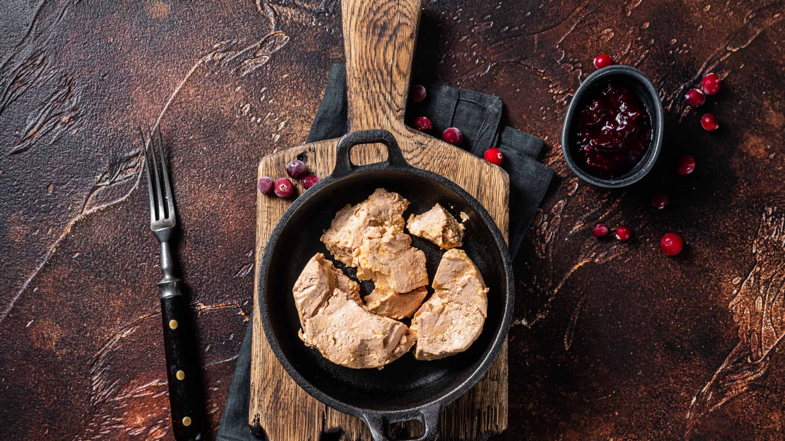 Franch Foie gras duck liver pate with lingonberry marmalade. Dark background. Top view