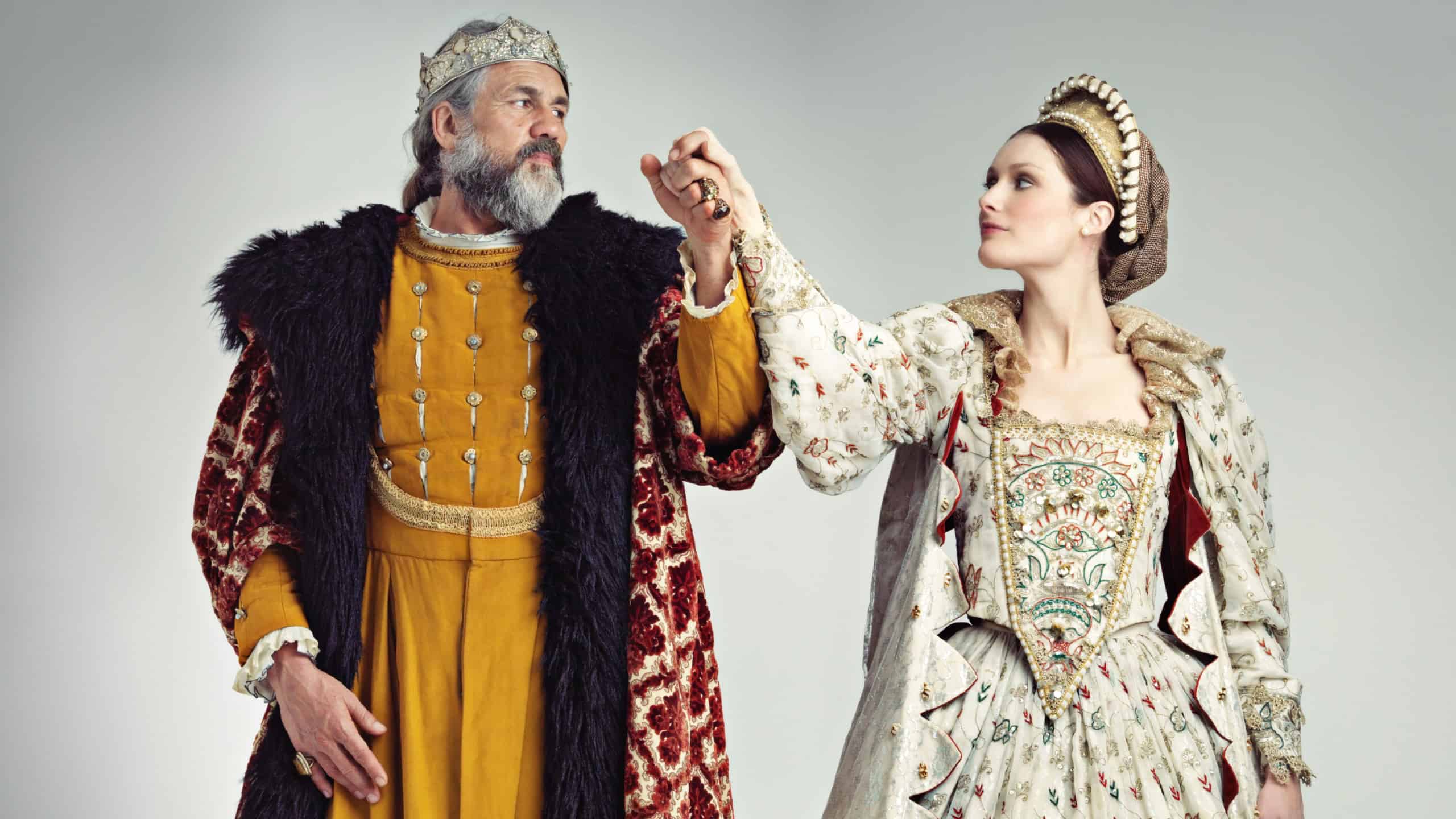 Medieval, love and king with queen in studio on gray background for power, ruler and leadership. History, theatre and isolated royal couple holding hands in vintage, renaissance and Victorian cosplay