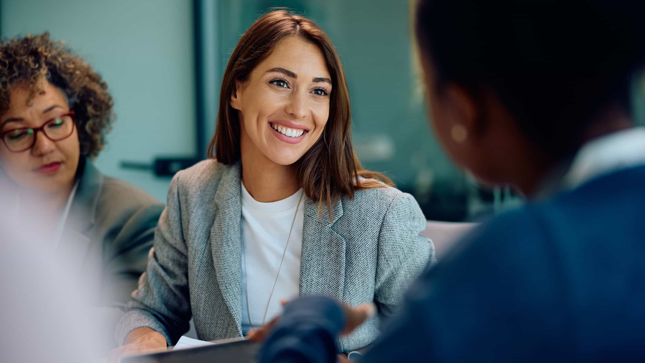 Young happy businesswoman talking to her colleagues during a meeting in the office.