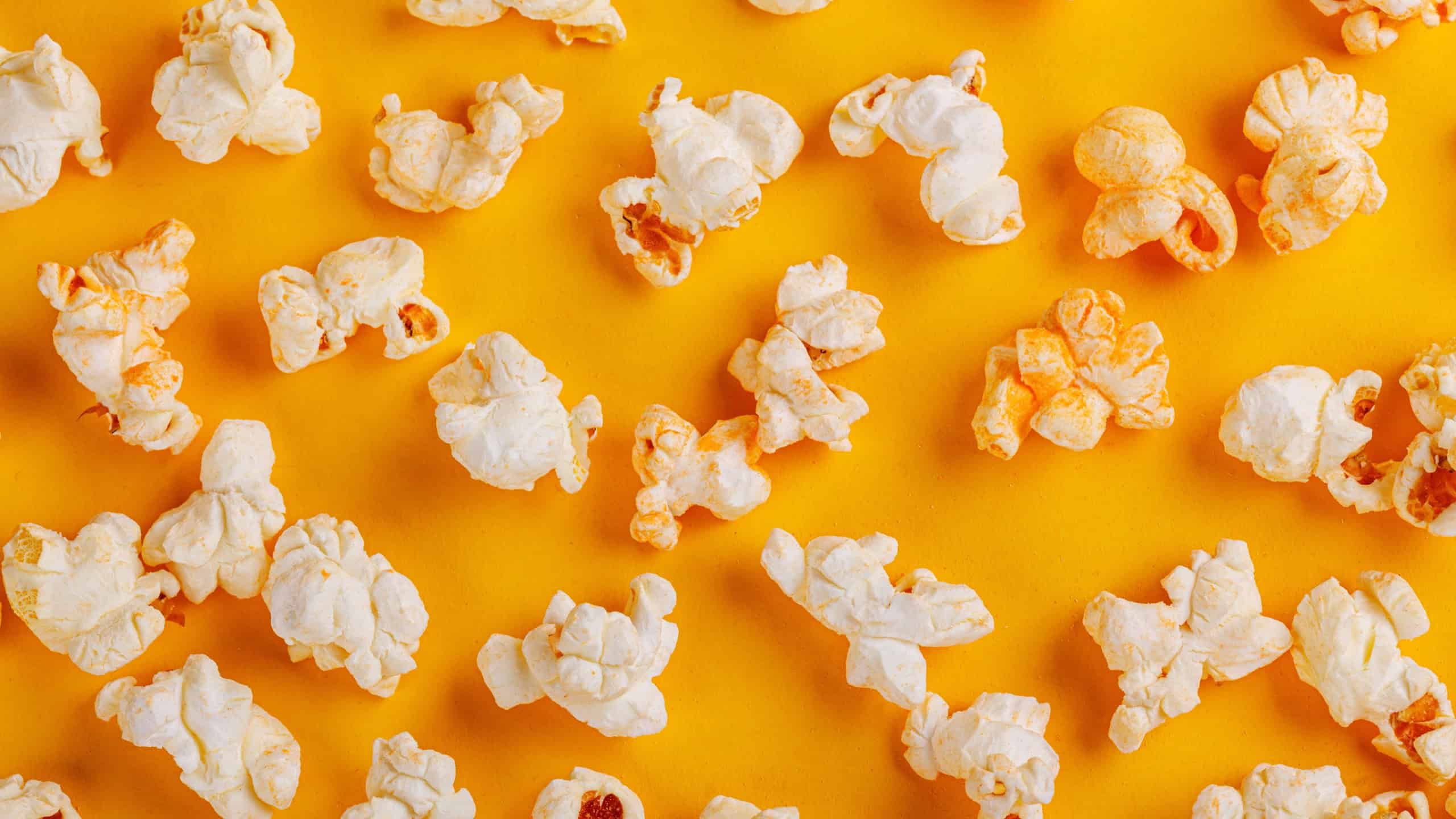 Box with popcorn on a yellow background close-up