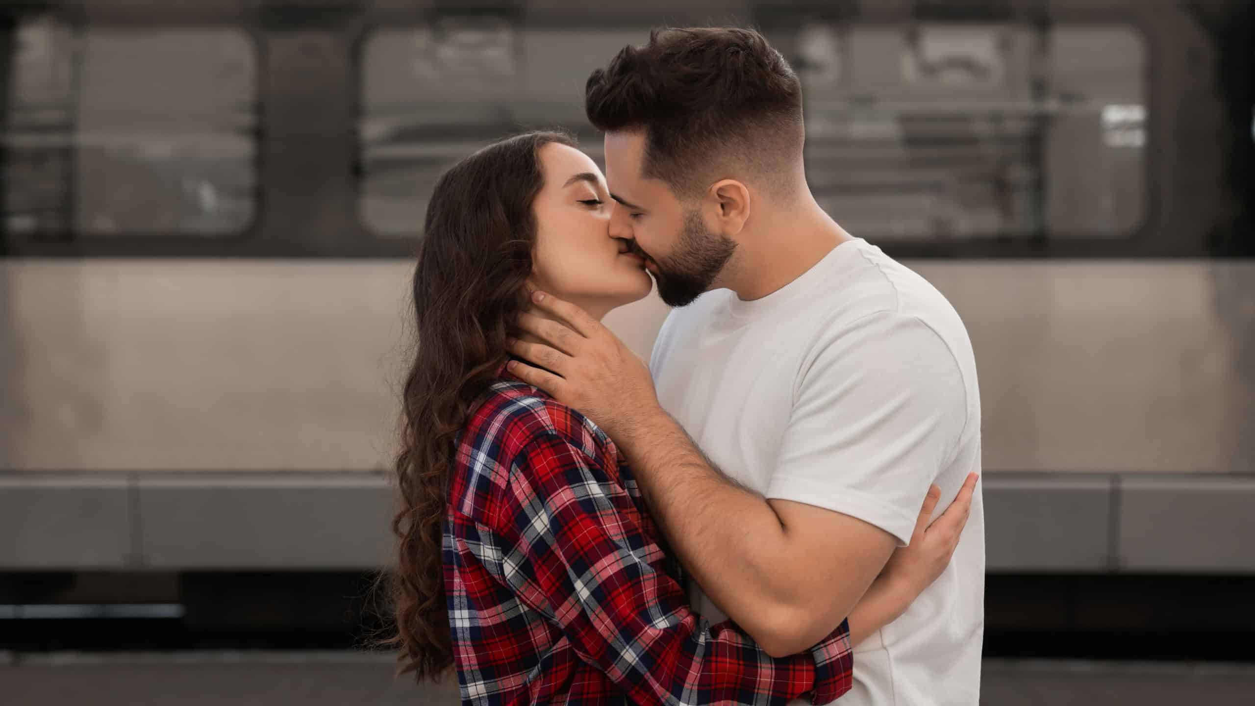 Long-distance relationship. Beautiful couple kissing on platform of railway station