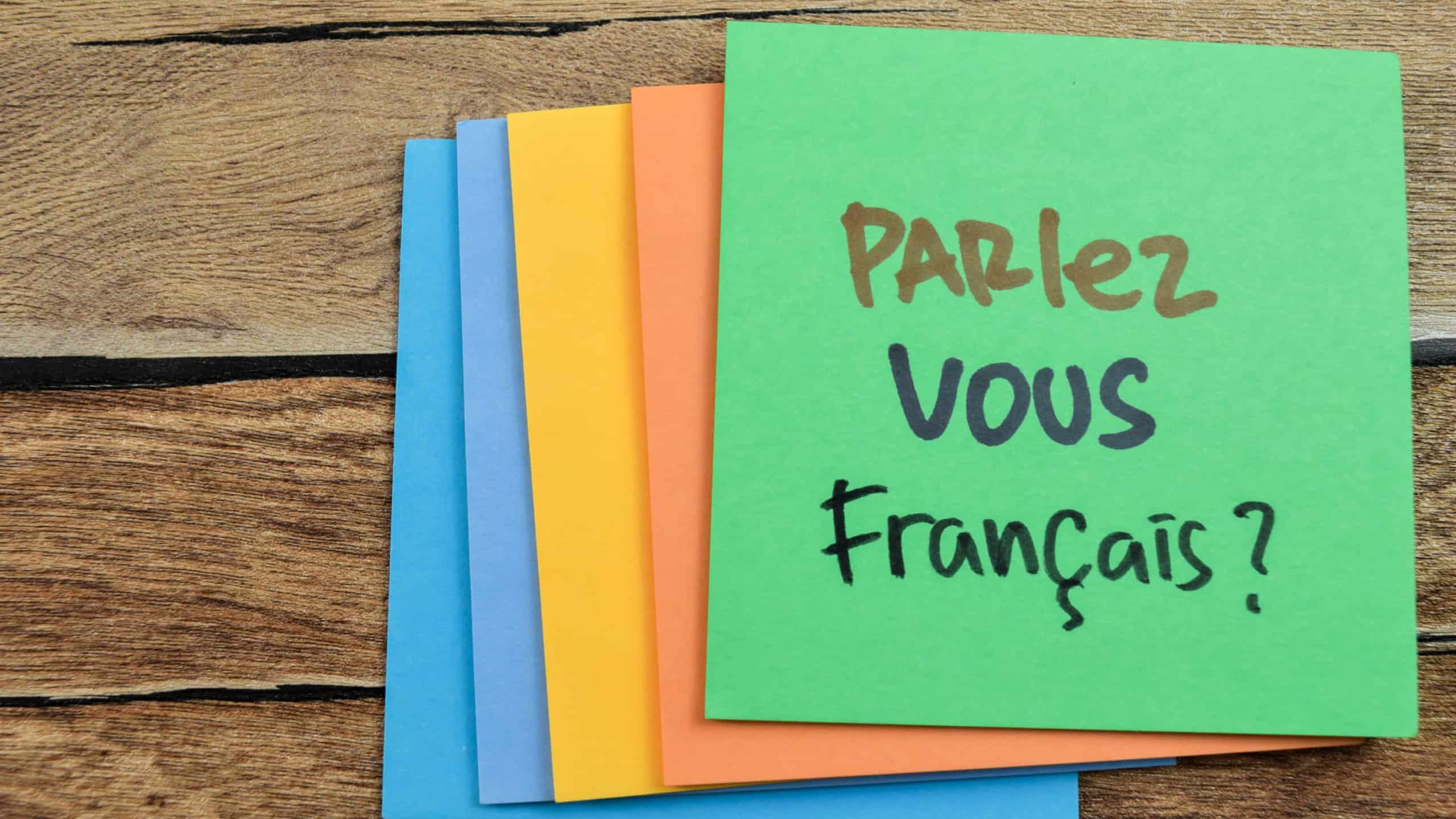 Concept of Learning language - German. Parlez Vous Francais it means Do you speak French written on sticky notes. German language isolated on Wooden Table.