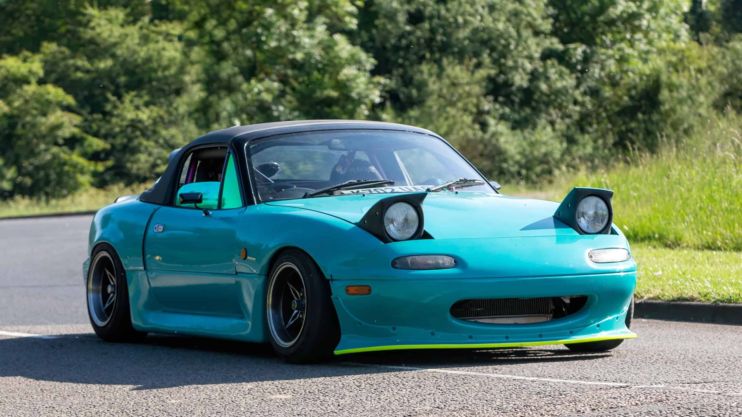 Stony Stratford,UK - June 2nd 2024: 1992 Mazda MX-5 with pop up headlights car driving on a British country road