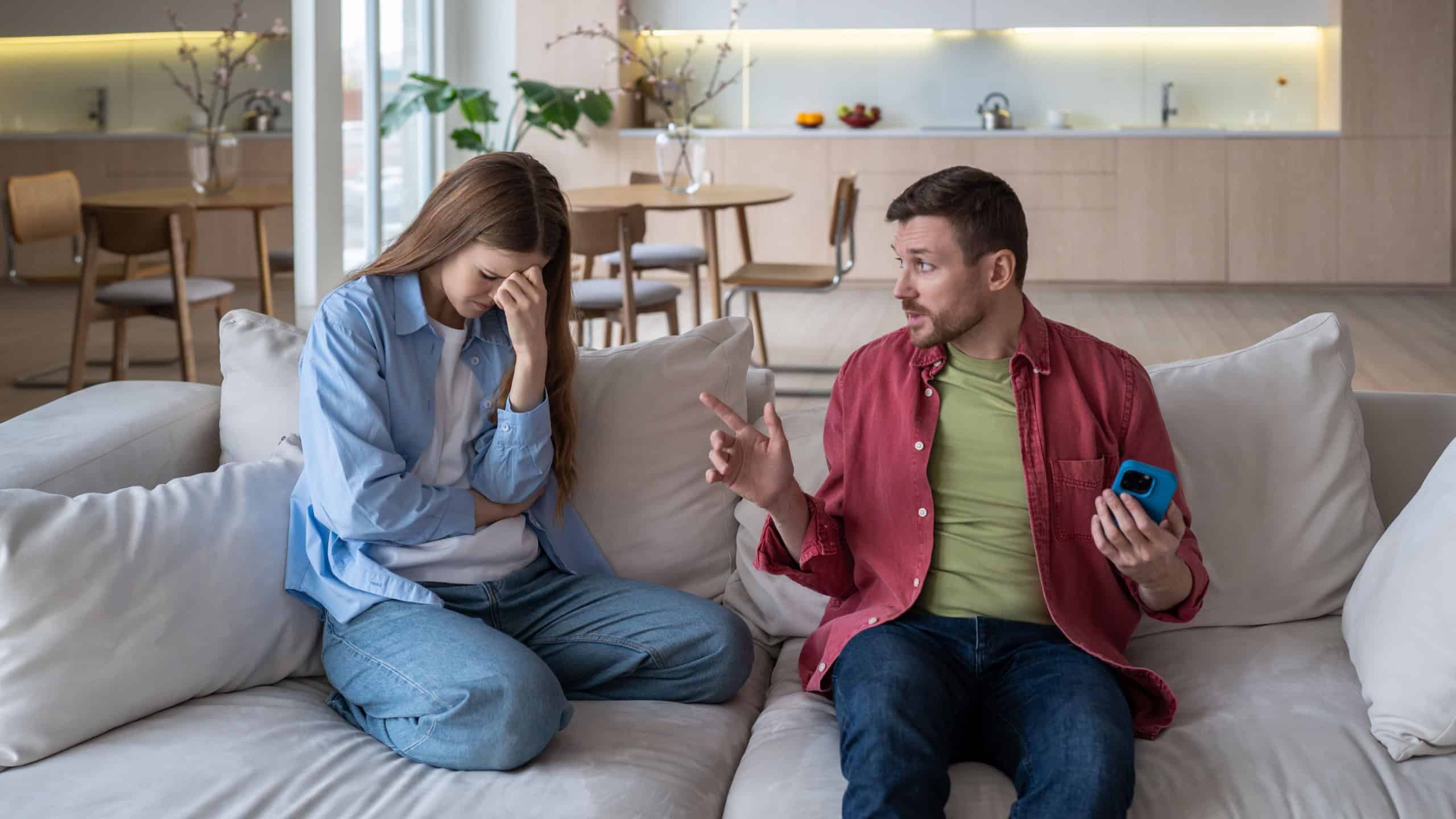 Scandal between spouses due to distrust, jealousy, cheating. Incredulous woman secretly got into guy's phone without permission. Secretive man scolds woman for stalking, violating personal boundaries