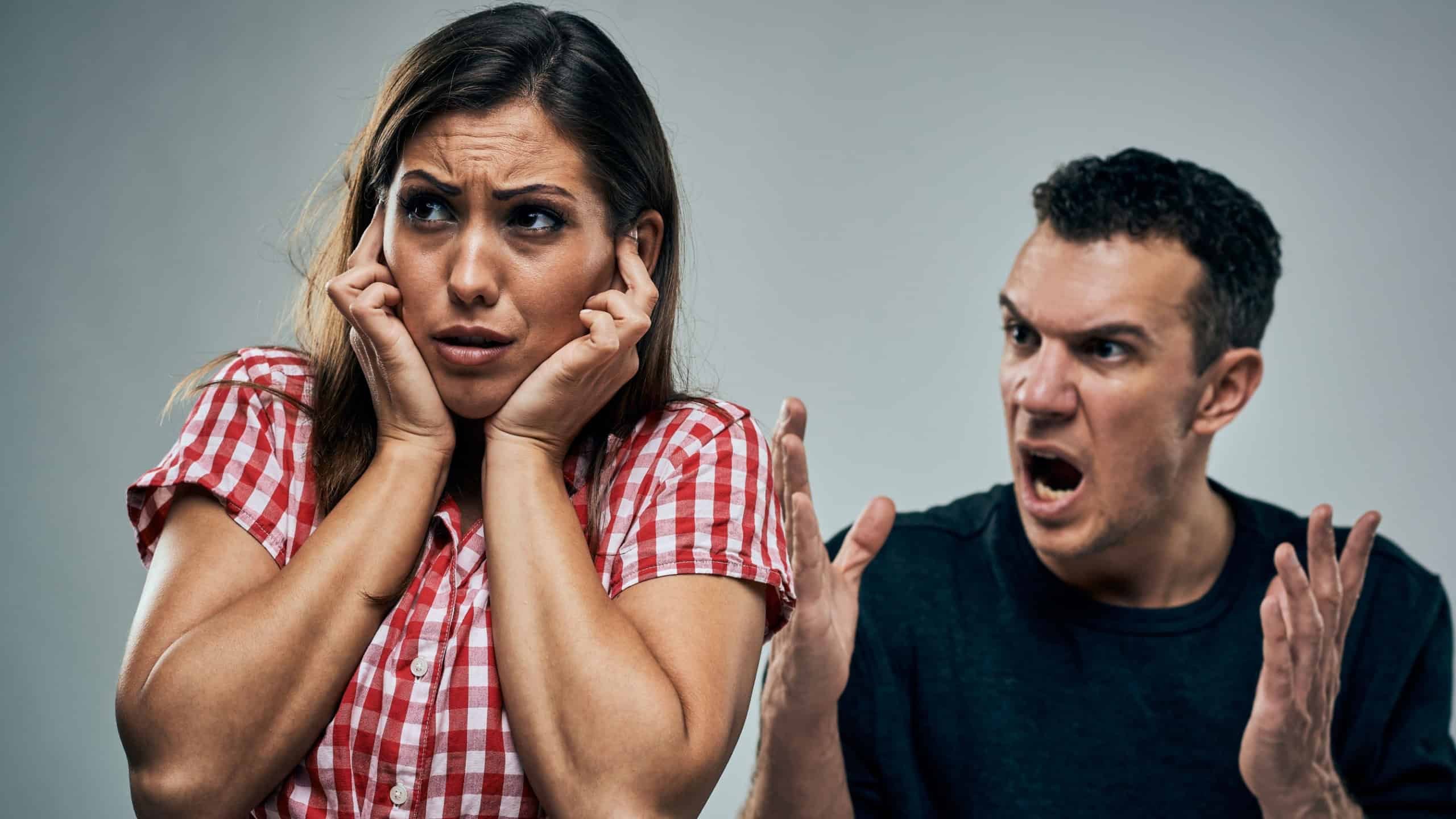 Young man angrily yells at his girlfriend at tense moment of conflict and frustration.