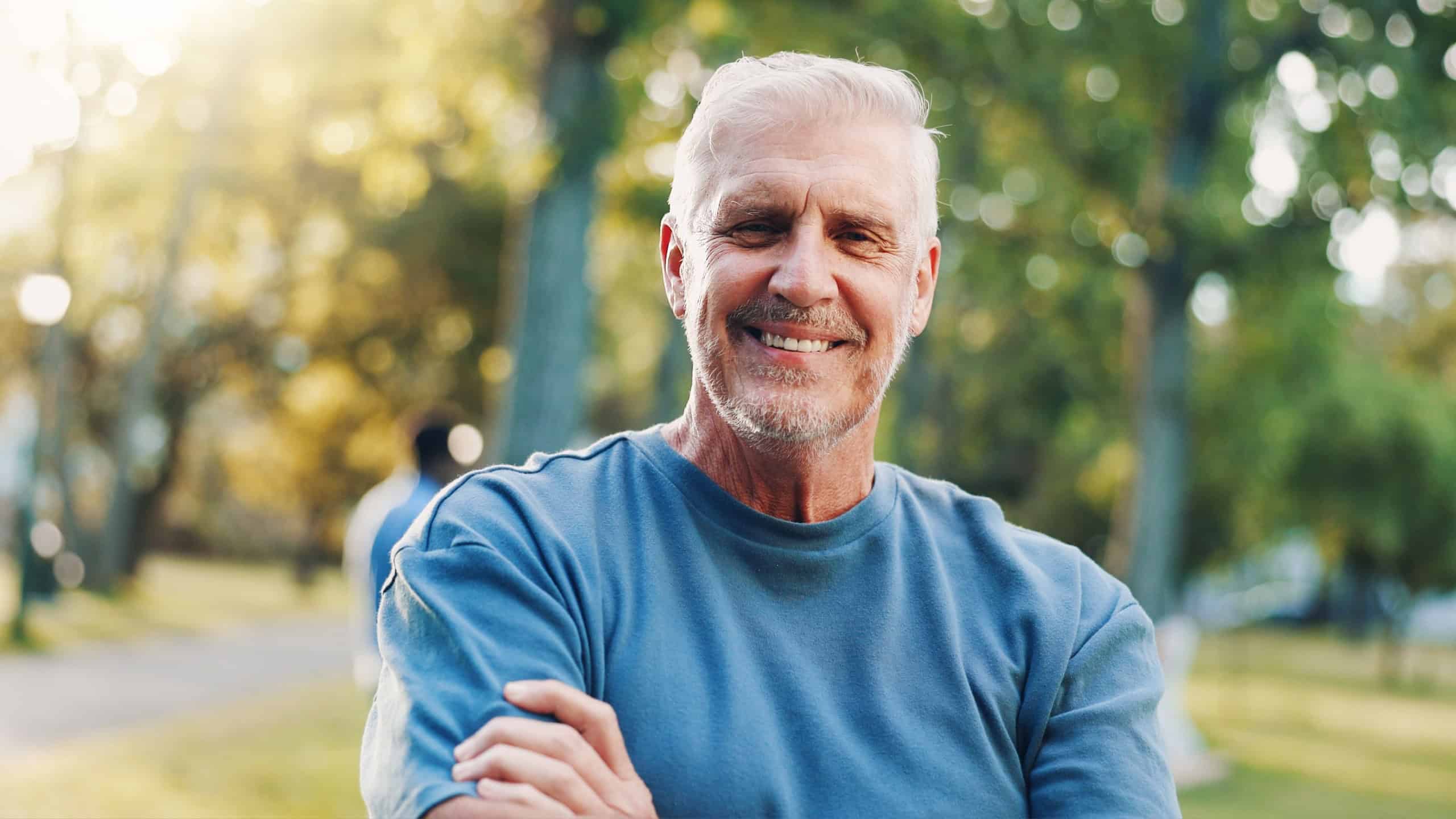 Portrait, senior and man in outdoor fitness for running exercise, training and morning routine. Smile, elderly person and arms crossed with cardio workout, wellness practice and pride for retirement