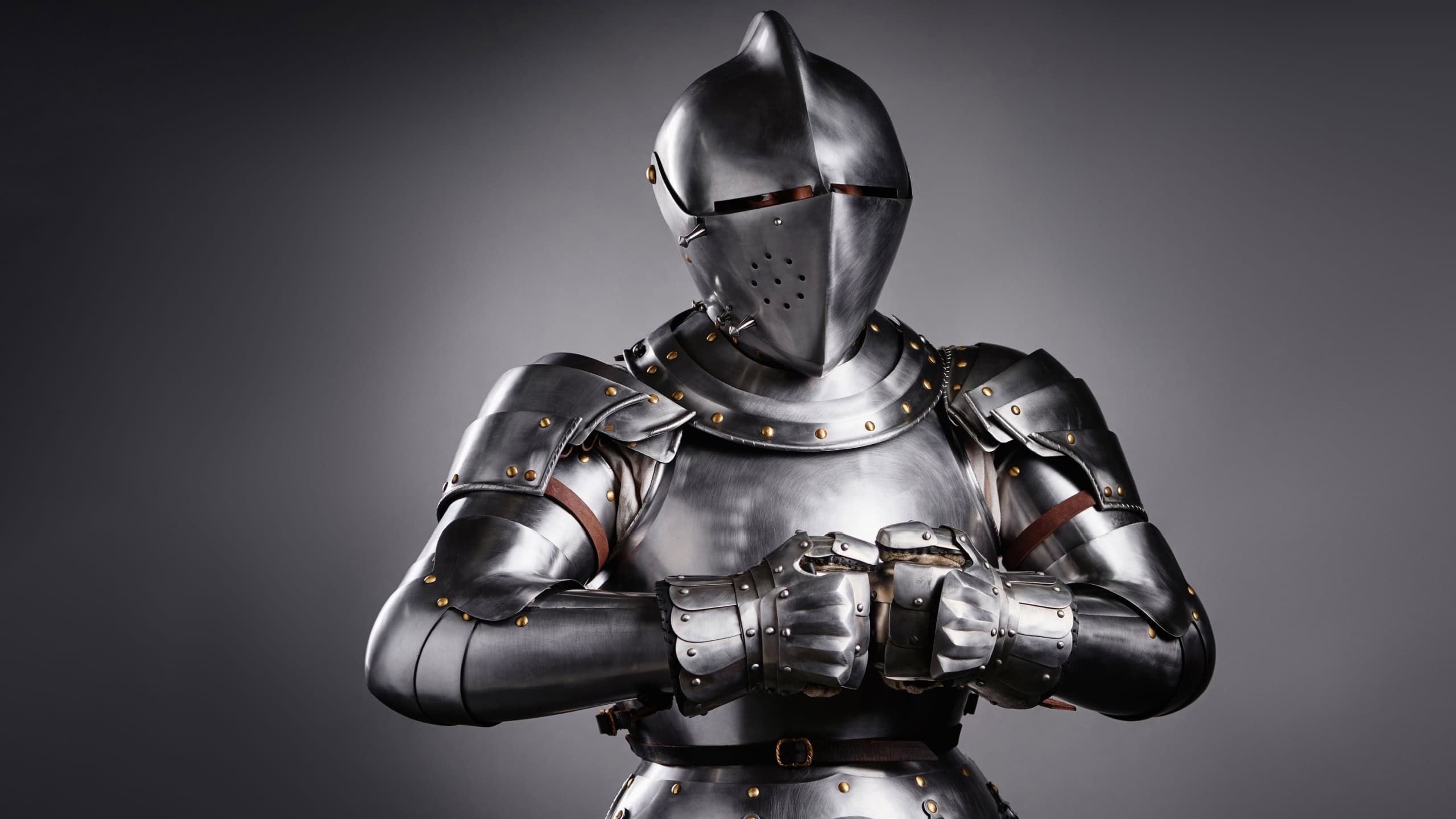 Detailed image of a medieval knight's steel armor, showcasing intricate craftsmanship, in a studio setting with dramatic lighting emphasizing textures and materials.