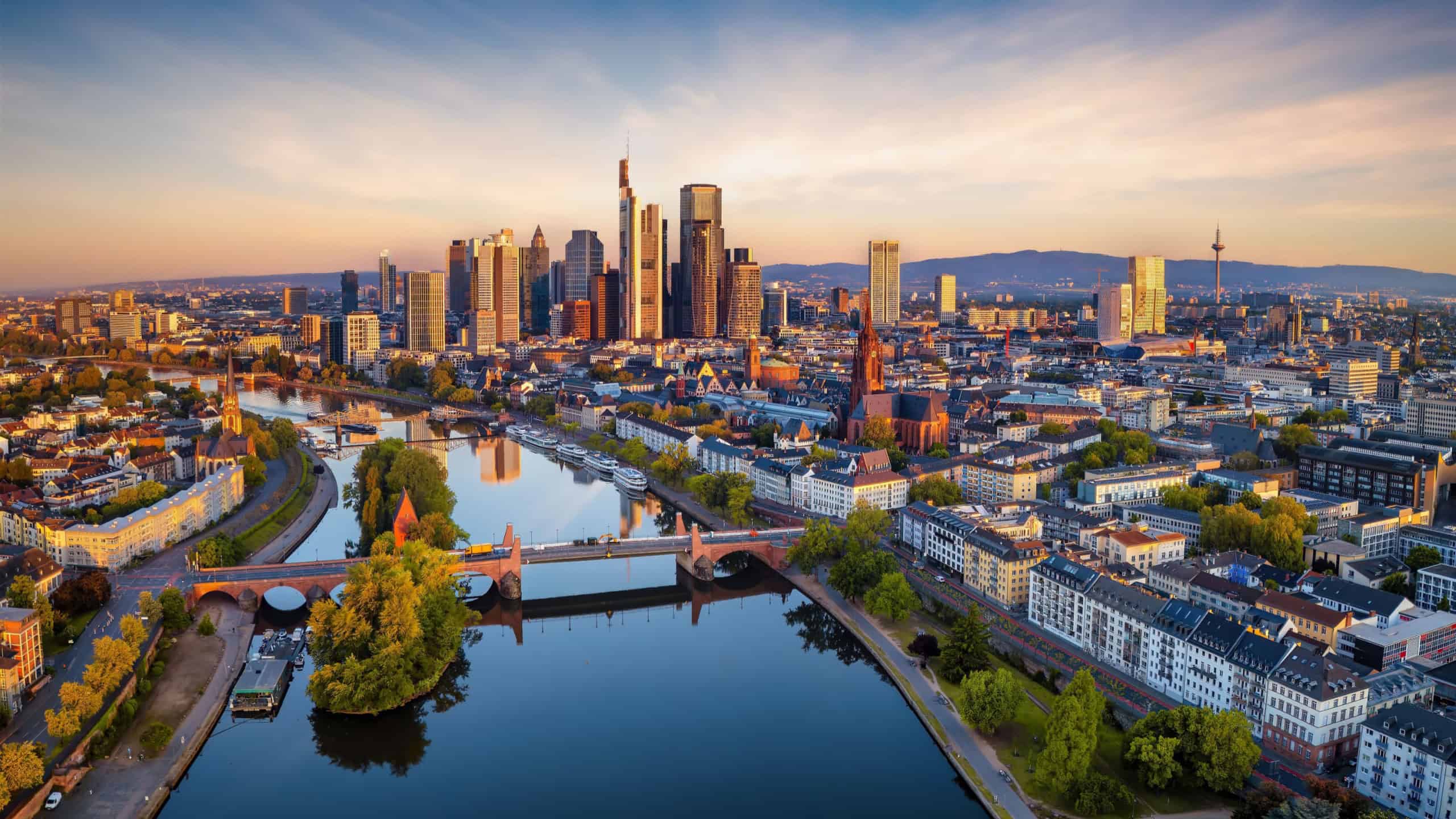 Panoramic aerial view of the skyline of Frankfurt am Main, Germany, with golden morning sunlight reflecting from the office skyscrapers
