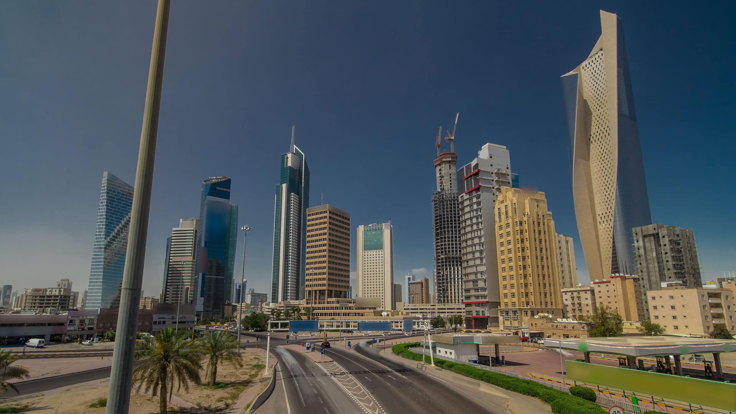 Kuwait City skyline with skyscrapers timelapse hyperlapse in downtown. View from bridge with traffic on the road. Kuwait City, Middle East.