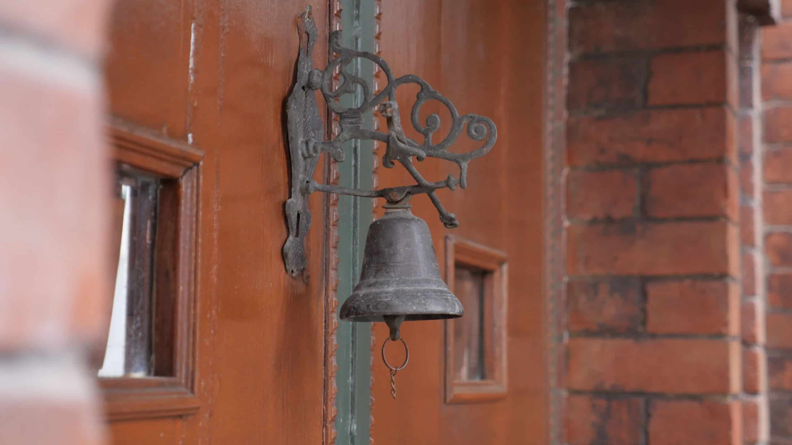 Vintage bell mounted on rustic wooden door