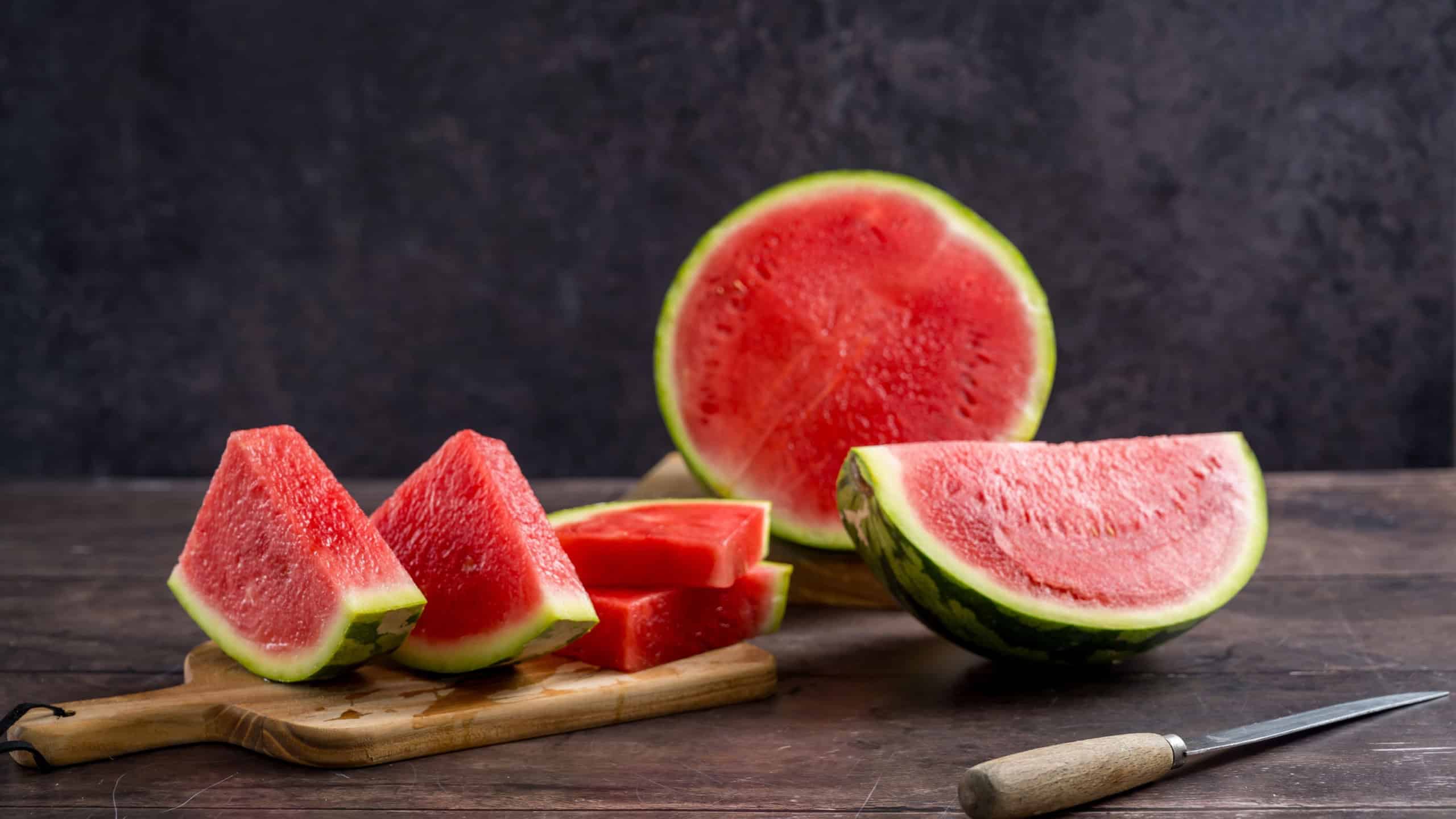 Slices of fresh watermelon on the rustic wooden table, dark background